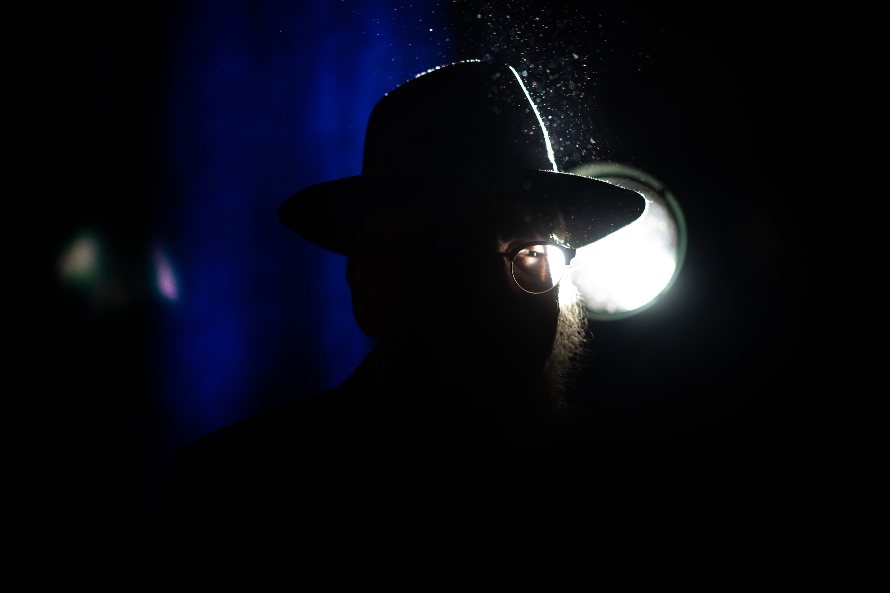  A Chabad-Lubavitch rabbi is silhouetted against a stage light at the end of a banquet in Suffern, NY. Each year, the International Conference of Chabad-Lubavitch Shluchim, or emissaries, takes place in the New York City area for six days. 