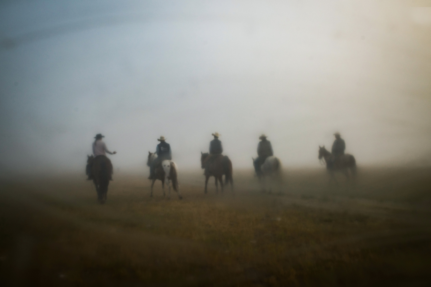  45º25'37.9"N, 102º17'10.7"W. 113 miles from the nearest McDonald's. The Arneson family and their employee Riley Cihak ride their horses through thick morning fog on their ranch in the old town of Chance, SD. The Arnesons family moved from Montana to