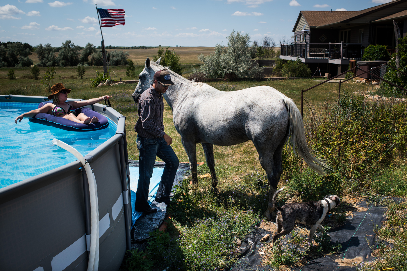 45º30'35.5"N 102º13'48.2"W. 124 miles from the nearest McDonald's. Jessica Lawson holds the war bridle on Fred the horse as her boyfriend Shane Yalowizer goes to get ready for a swim on his ranch in Meadow, SD in July, 2017. 