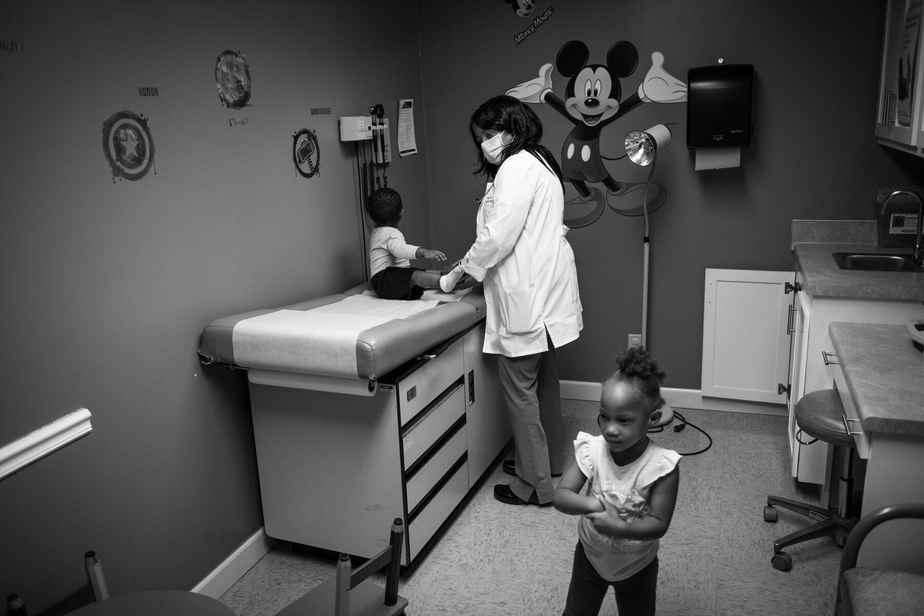  Dr. Mary Williams performs a checkup on Ja’kayah Wade, right, and Jarvarius Ewings, left, at her clinic in Clarksdale, MS. Williams had a difficult childhood, with a mother who she believes was likely developmentally delayed, and out of a large fami