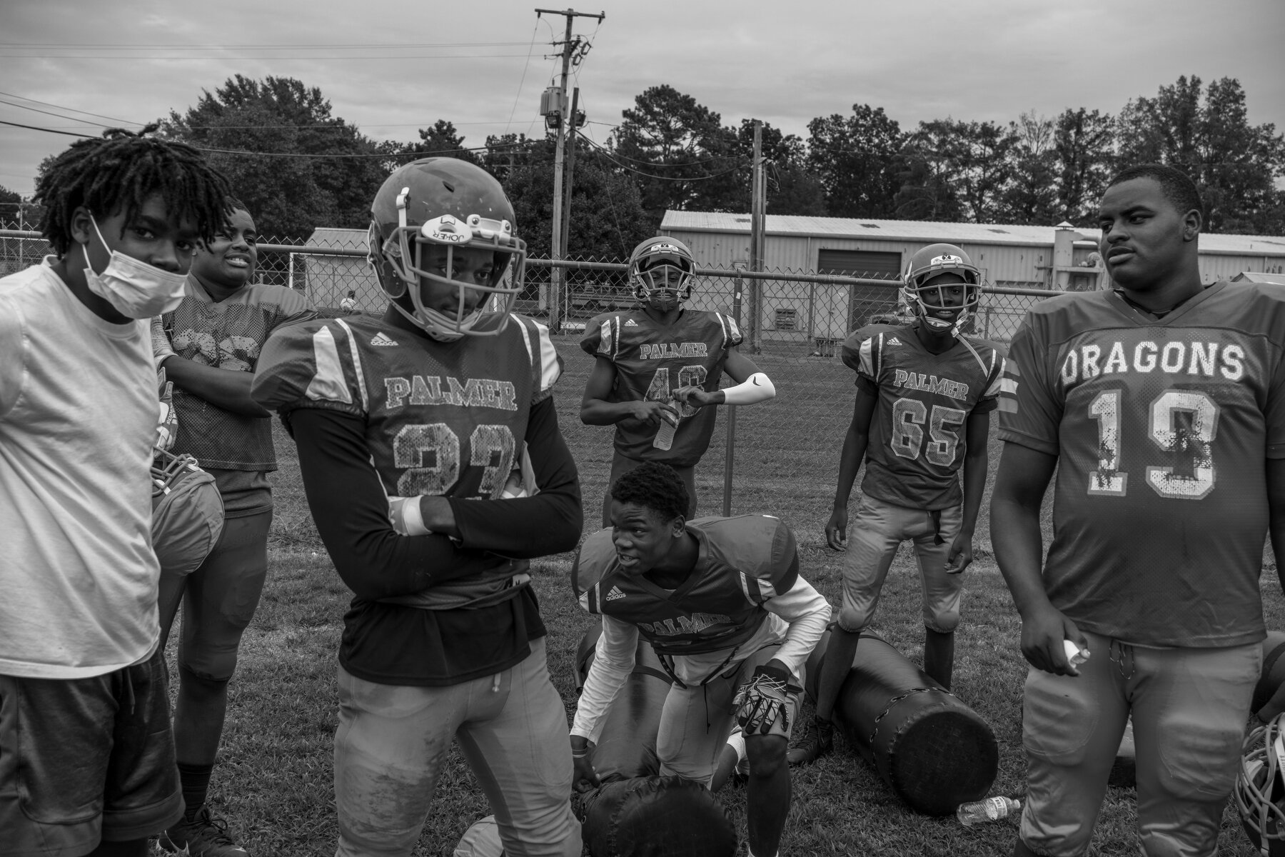  Players from the Madison Palmer Senior High School Dragons football team rest on the sidelines during practice in Marks, MS. The team had its season initially cancelled due to the COVID-19 pandemic, then the season was reinstated, but after playing 