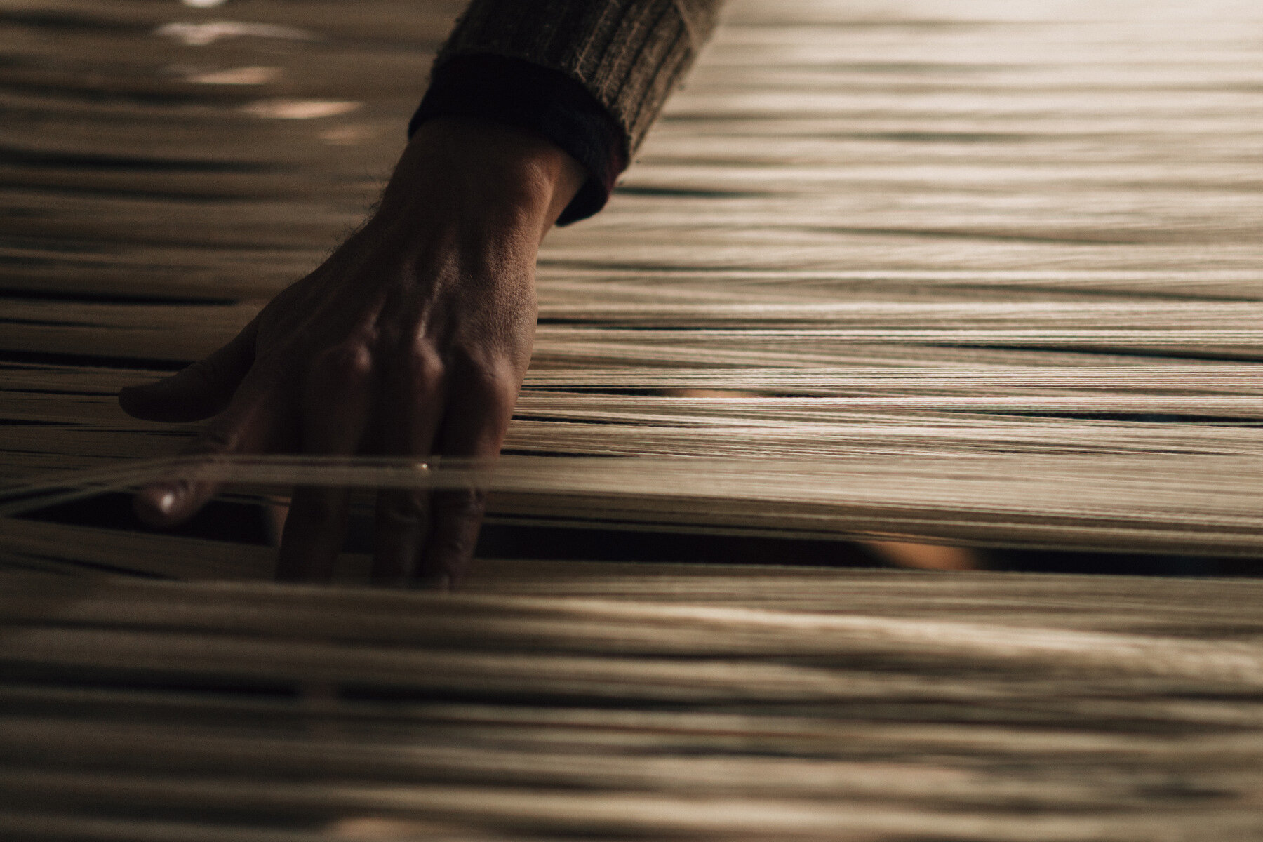  Justin Squizzero runs his fingers through the warp threads on his loom that may date back to 1650. 