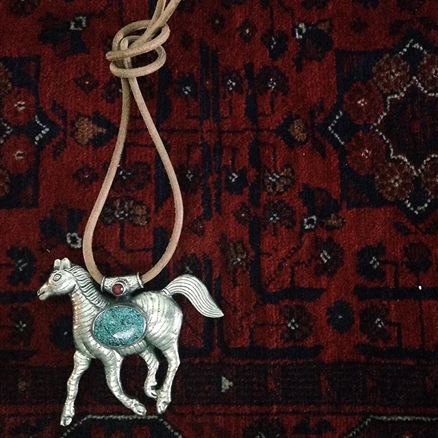 A silver 'galloping horse' pendant from Tibet.