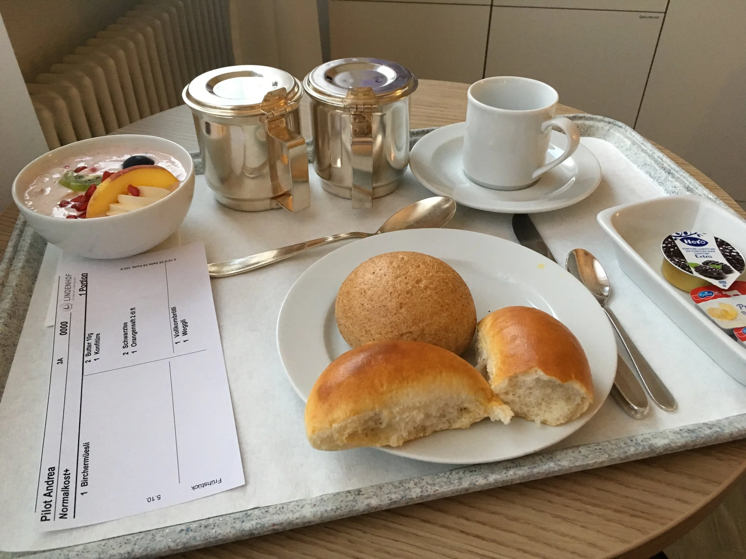 Hospital breakfast: birchermüesli, rolls, butter and jam, warm milk.