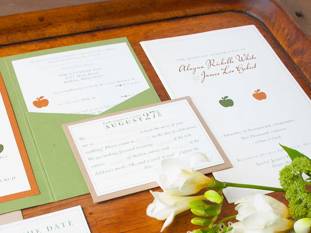 Mossy green, apple red and autumn orange rustic fall invitation design. Includes a moss green envelopment, main invite, R.S.V.P. mad libs card, save the date postcard, program and custom map of local area with nearby must-see places recommended by the couple and directions to the ceremony to the reception. All items enclosed in a kraft paper envelope.