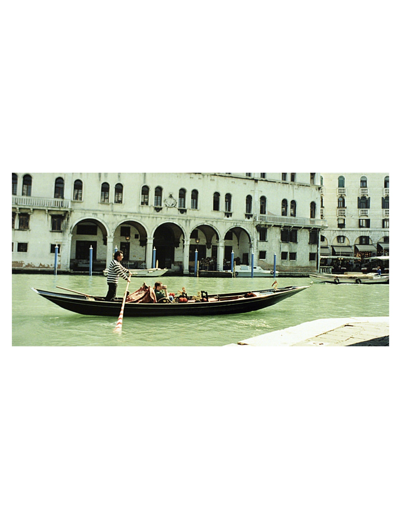 A sandolo (another style of Venetian boat) cruising toward the Rialto Bridge in Venice 2004. Photo by John Synco