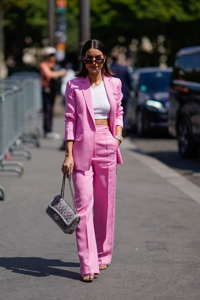 Camila Coelho wears a pink blazer jacket, pink flared pants, a Chanel_.jpeg