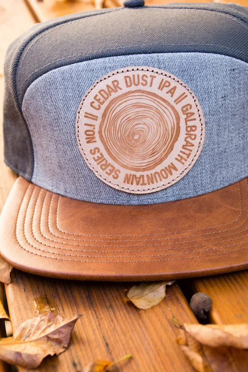 5-Panel Cedar Dust Hats Custom, one-of-a-kind five-panel Cedar Dust Hat I designed from scratch, materials and all. The cap features a distressed leather bill with two-tone gray panels. I created the cedar dust logo and worked with Blind Alley Leather Co. to create the burned patches. Each hat's patch is a little bit different making it a truly unique piece. More...