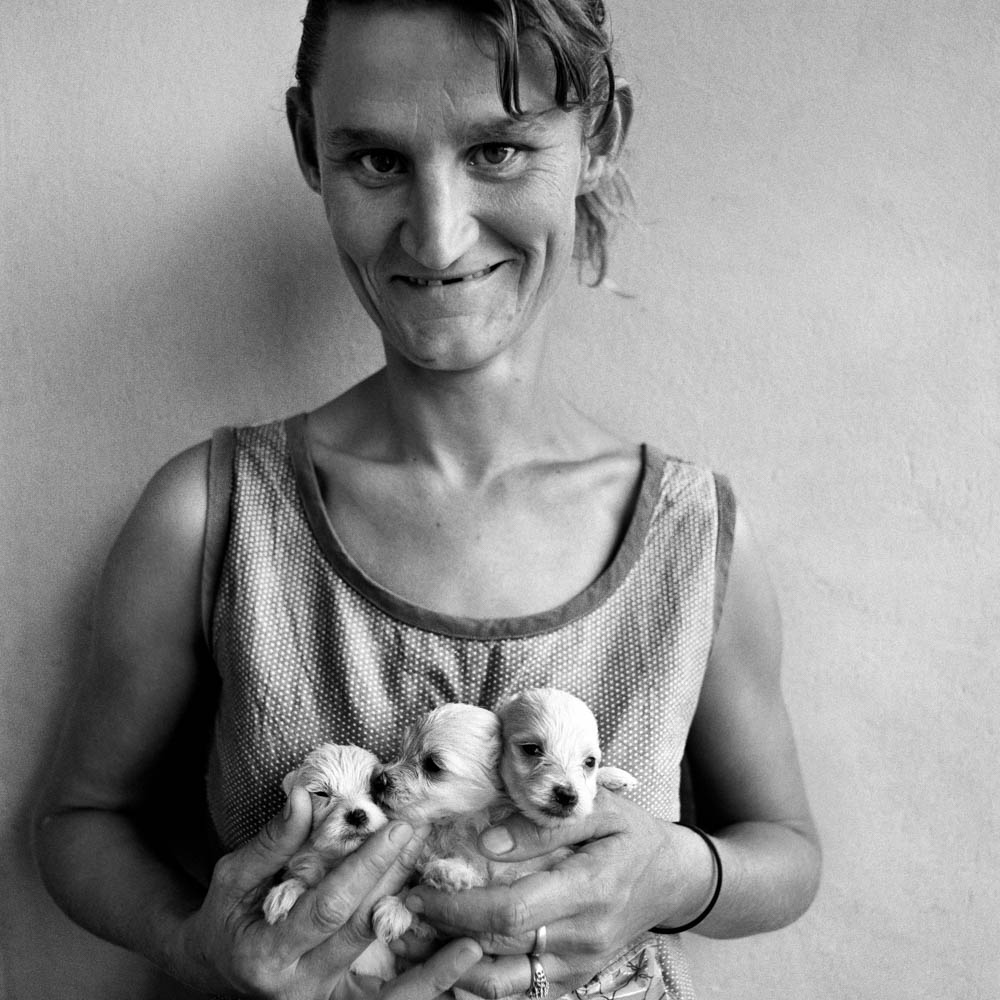 Roger Ballen Wife of Abattoir Worker Holding Three Puppies, Orange Free State - 1994