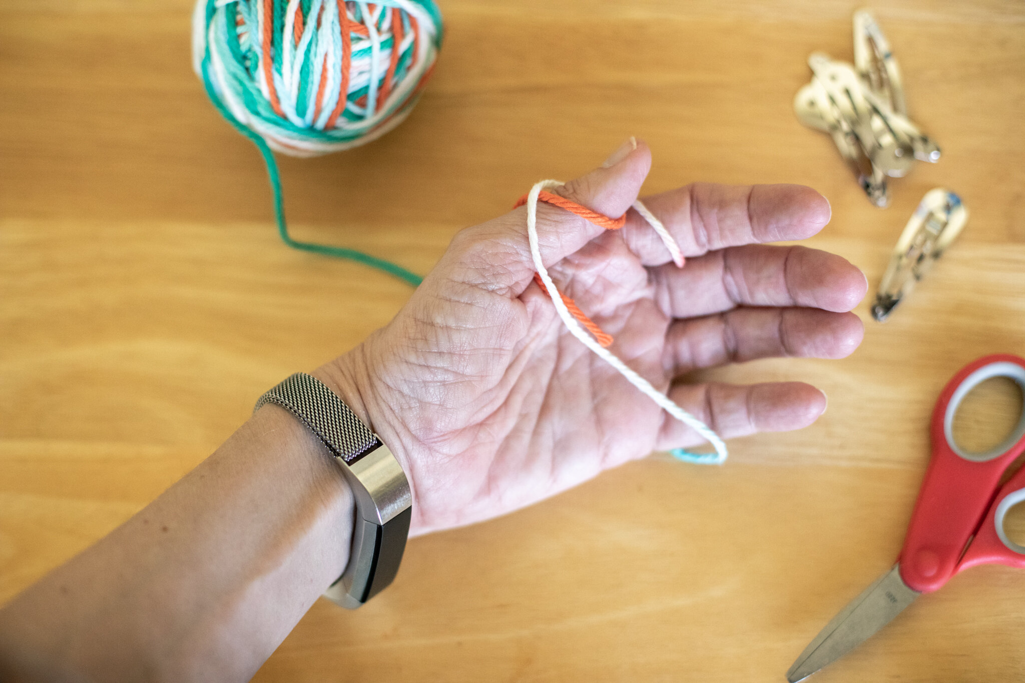 Keep the yarn a little loose (otherwise you might be wearing it forever). You will need to slip it off of your fingers at one point. Wrap the yarn around your thumb. Don’t let go of the “tail”. You should have two rings started on your thumb and fin