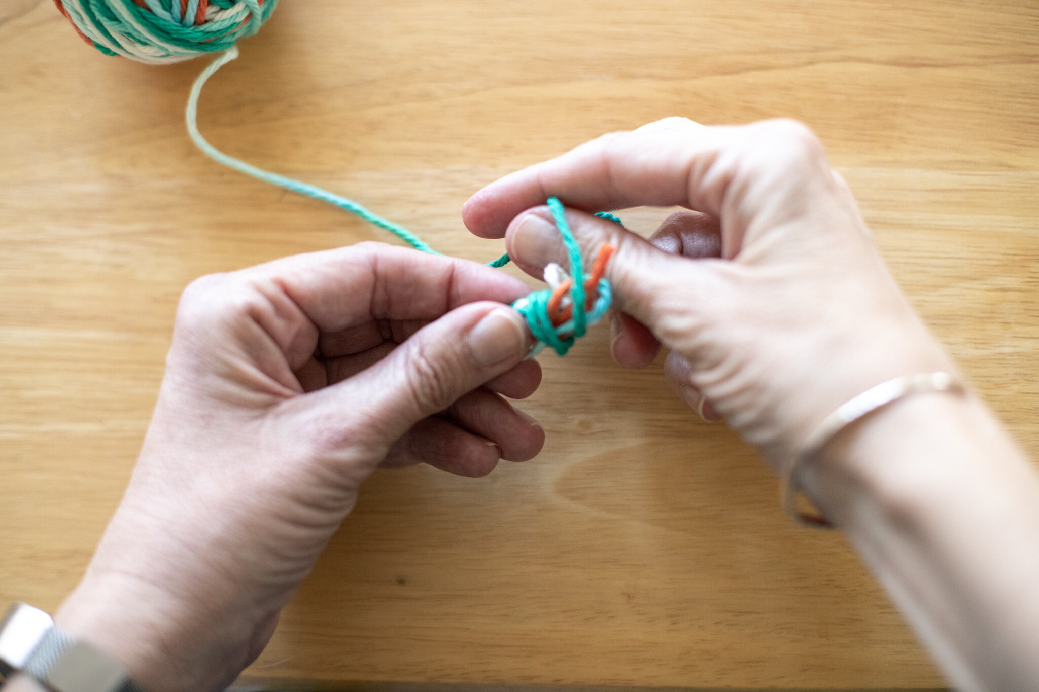  While holding the yarn, continue to wrap it around the loops. 