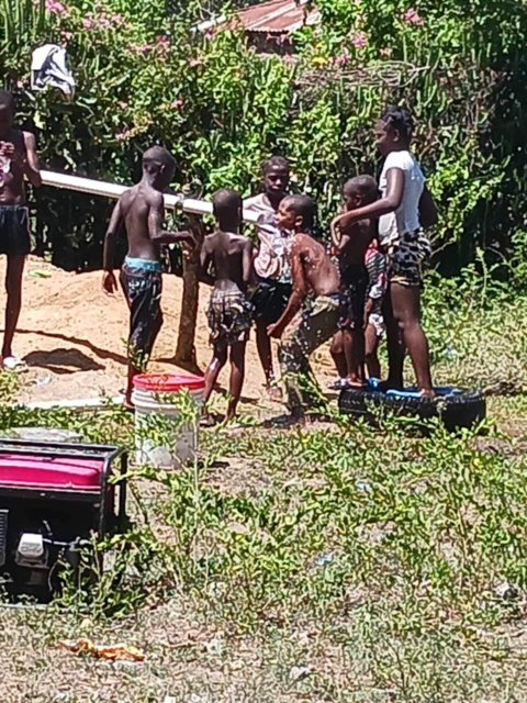 Children playing in water from one of our wells