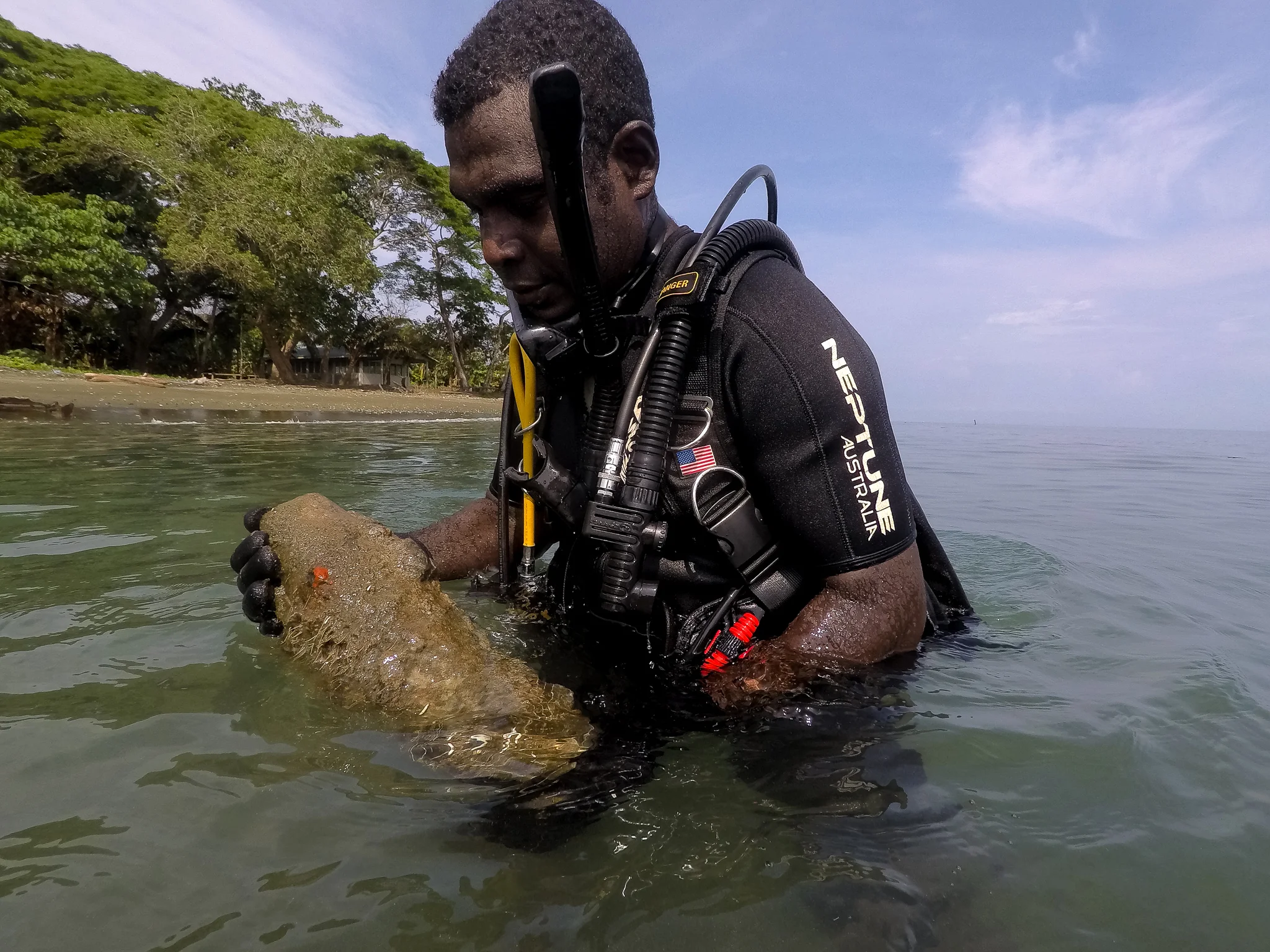  Police Constable Armstrong Ragoso carries a high explosive projectile out of the shallows at the mouth of the Alligator Creek in the Solomon Islands capital city, Honiara. During this dive, over 35 projectiles were discovered and hauled out, to be t