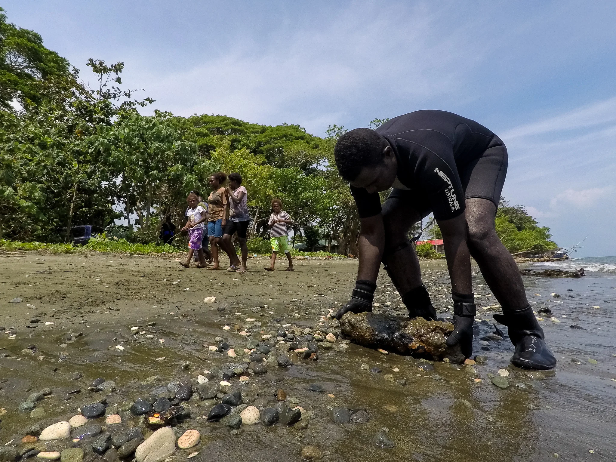  Police Constable Armstrong Ragoso picks up the final UXO found in a diving operation by the Explosive Ordnance Disposal team to be taken back to Hells Point for disposal. During the operation, over 35 explosives were found in waist high water at the