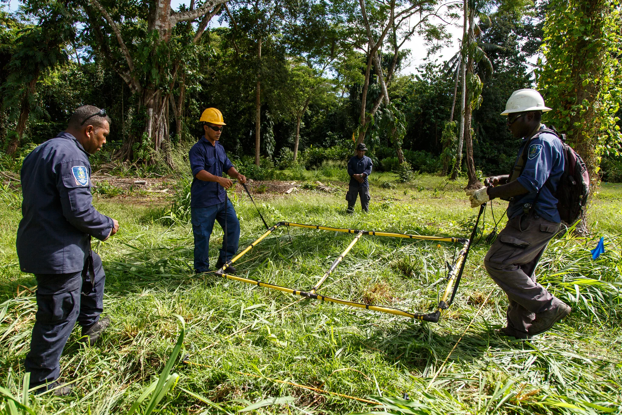  Police Constable Raymond Ake and Senior Police Constable Shelley Selestin Pelleni supervise as Police Constables Reinhard Alalo and Armstrong Ragoso use a large loop metal detector to clear a plot of land at Hells Point Range in Honiara. It is slow 