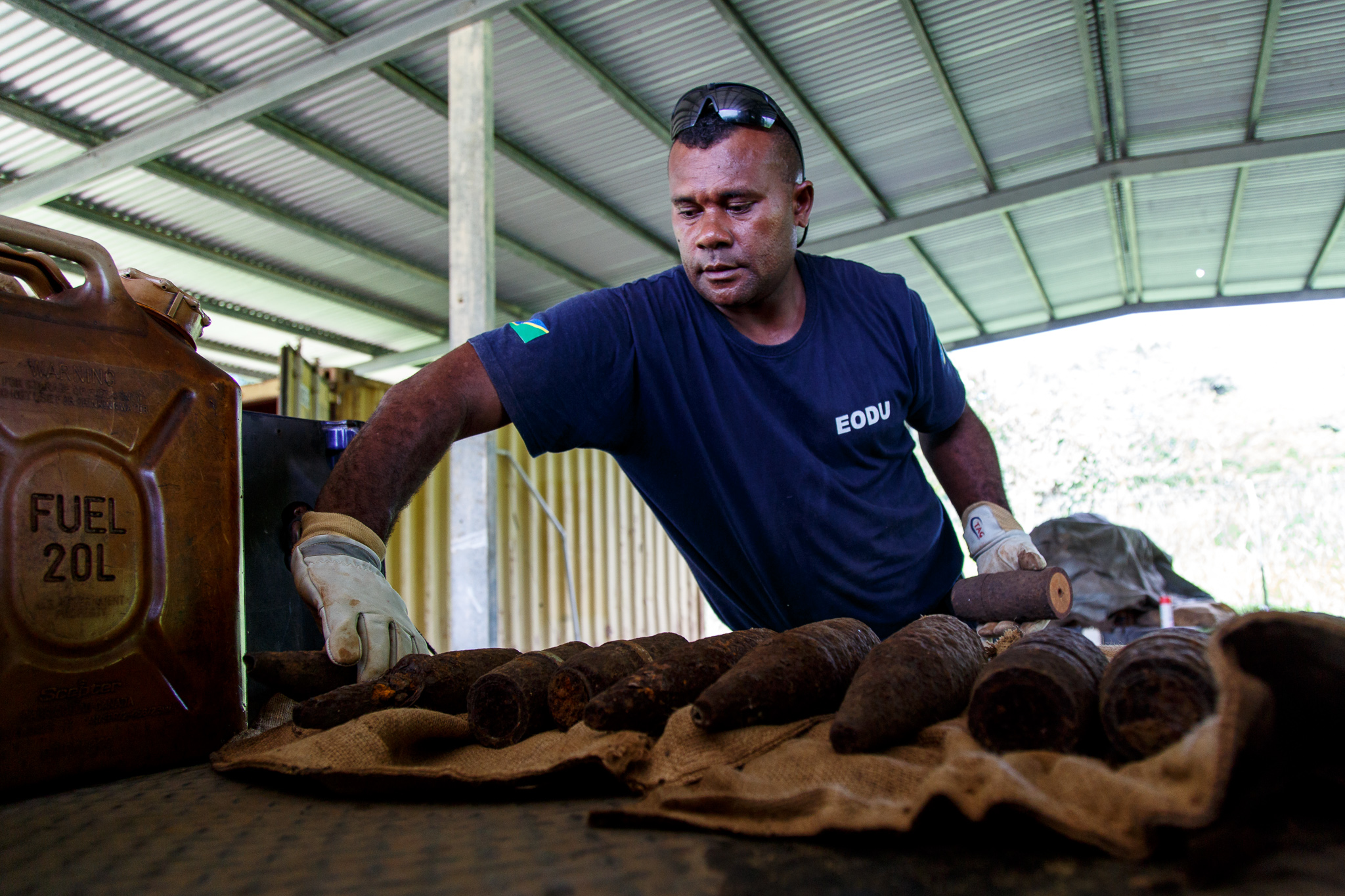  Sergeant Simon Rihia carefully places the cut UXO on the back of a truck to be taken to a remote pit and disposed of using their cut and burn technique. After the explosives are placed in the pit they will be covered with diesel soaked rags and lit 
