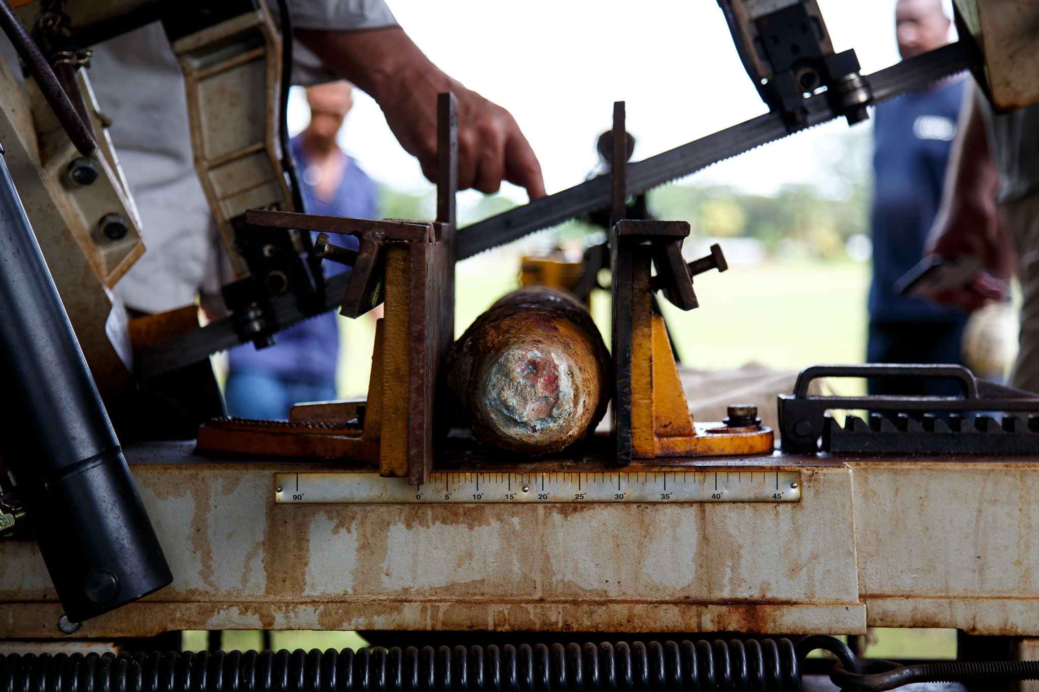  Once the explosives have been x-rayed to determine their inner explosive, the high explosive (TNT) filled projectiles are taken to a remote cutting shed. The projectile is then carefully measured and precisely cut using a remotely controlled bandsaw