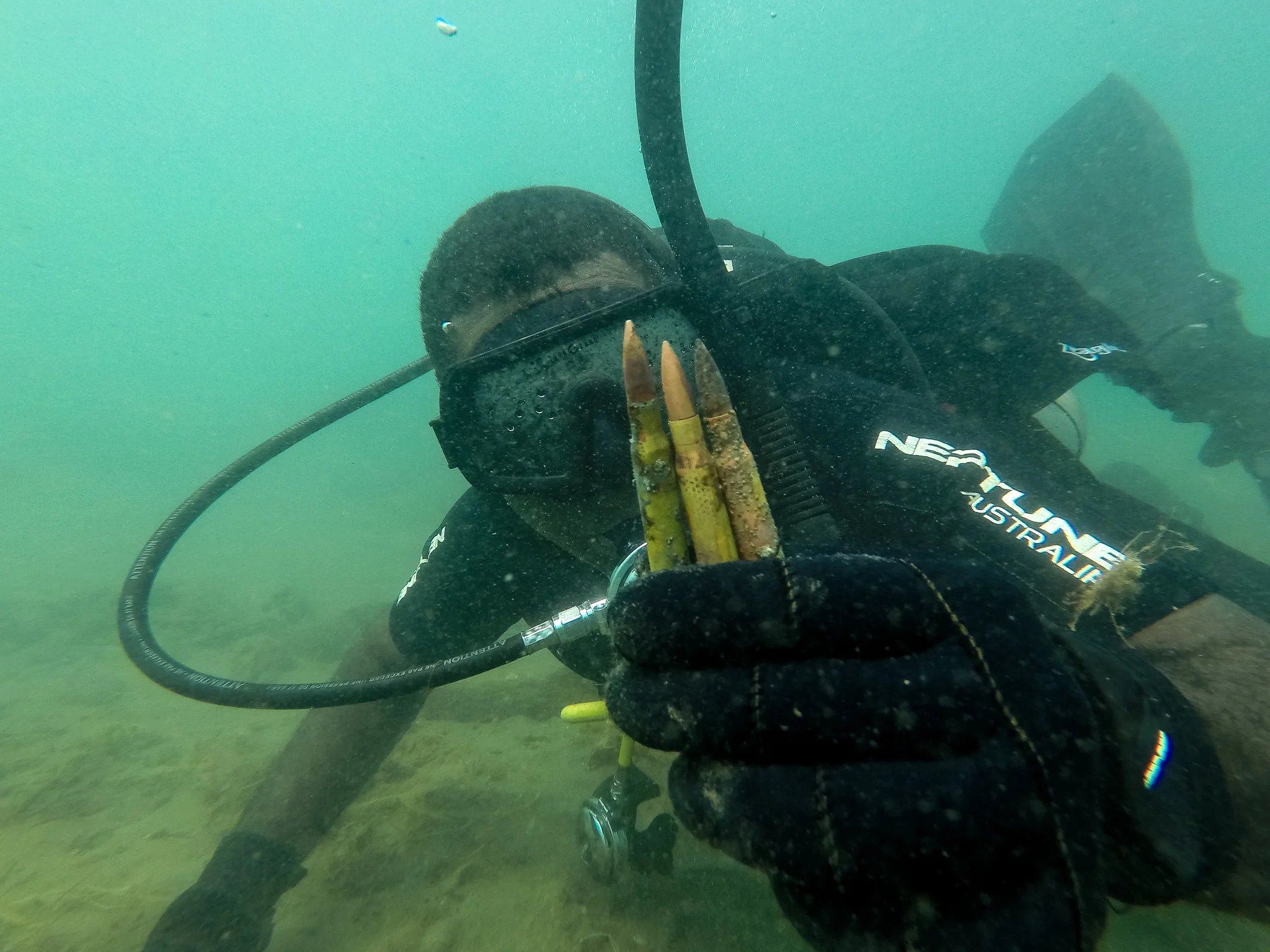  Police Constable Armstrong Ragoso finds three 50 calibre bullets from World War Two in the shallows of a busy beach in Honiara. During this dive, the team found 35 high explosive projectiles lurking in the shallows, completely crusted over with barn
