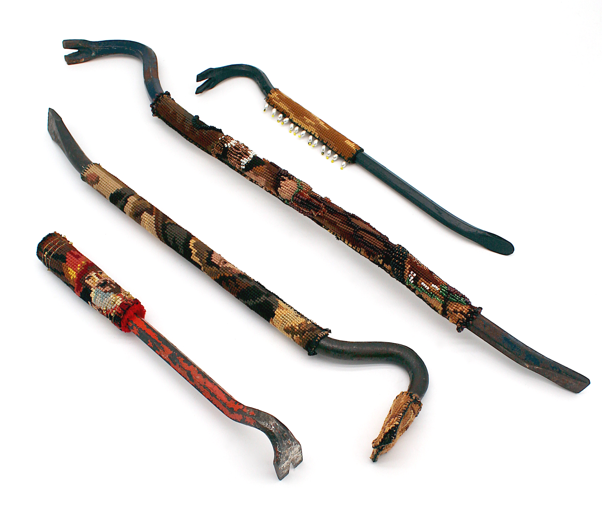 Three crowbars of various sizes with decorative woven and beaded coverings, displayed on a white background.