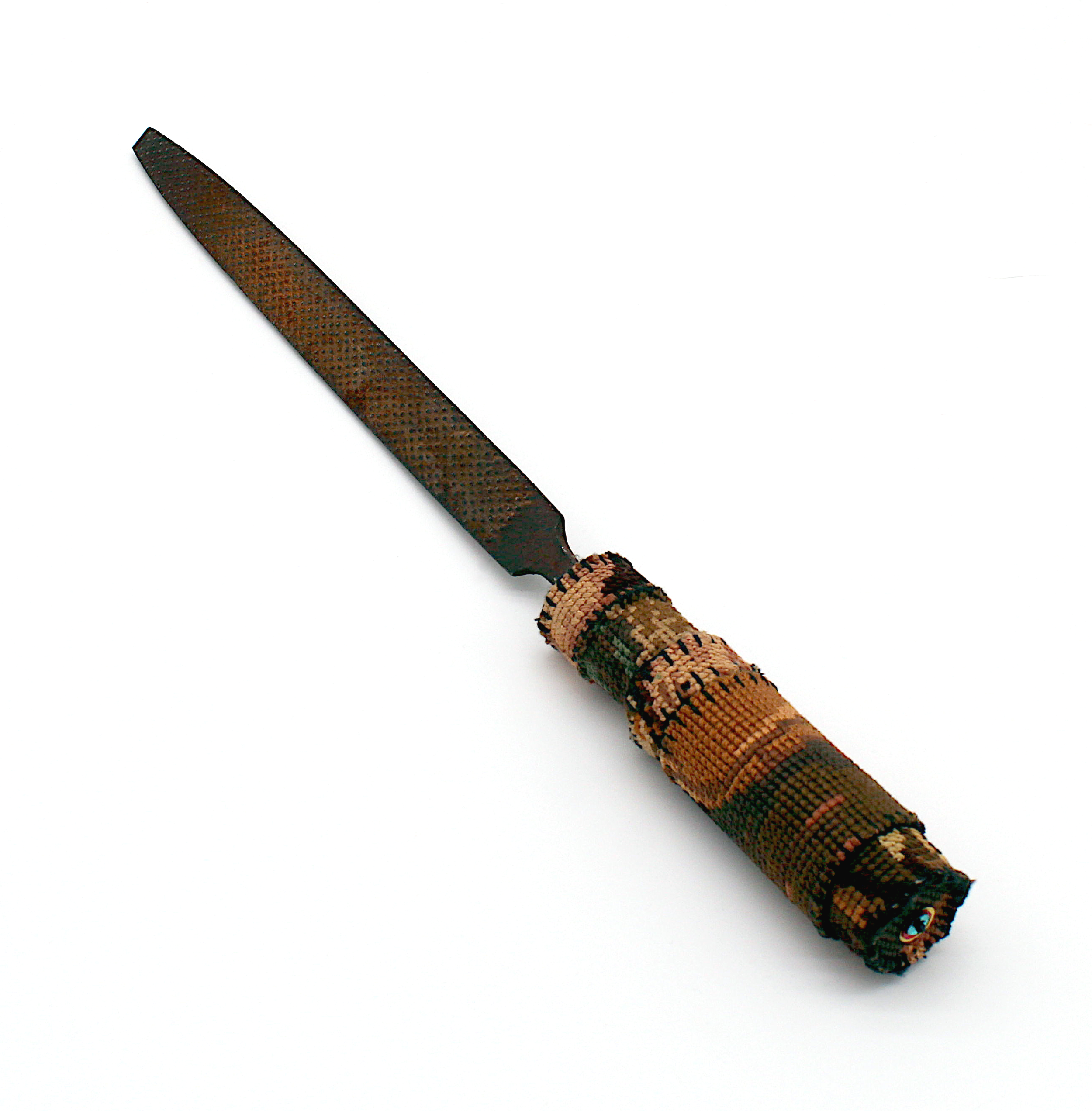 A rusty metal file, the wooden handle has been wrapped in a cross-stitch of the Rembrandt painting The Night Watch.