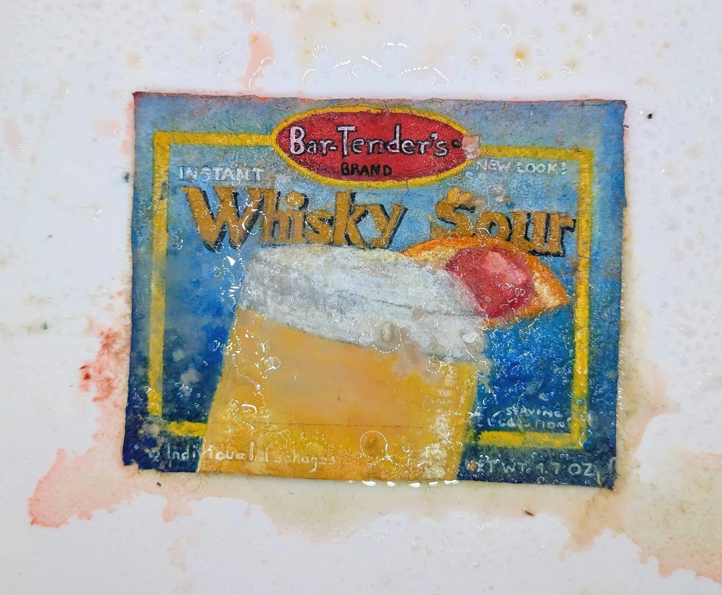 A paper seed bomb painted to look like a package of whiskey sour mix