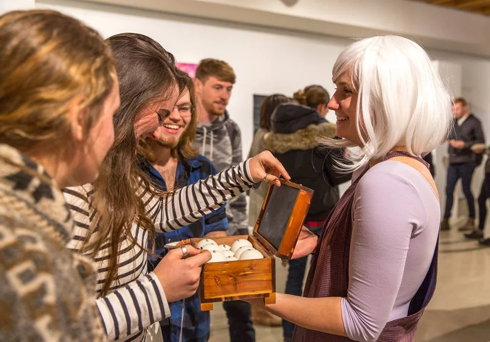 Secured by a small heart lock, the box is closed when at rest. A delicate key hung on a chain is worn by the artist when performing the piece. Viewers can unlock the box to read the message inside but are asked to lock it back up again so that each encounter with the message remains an intimate viewing.