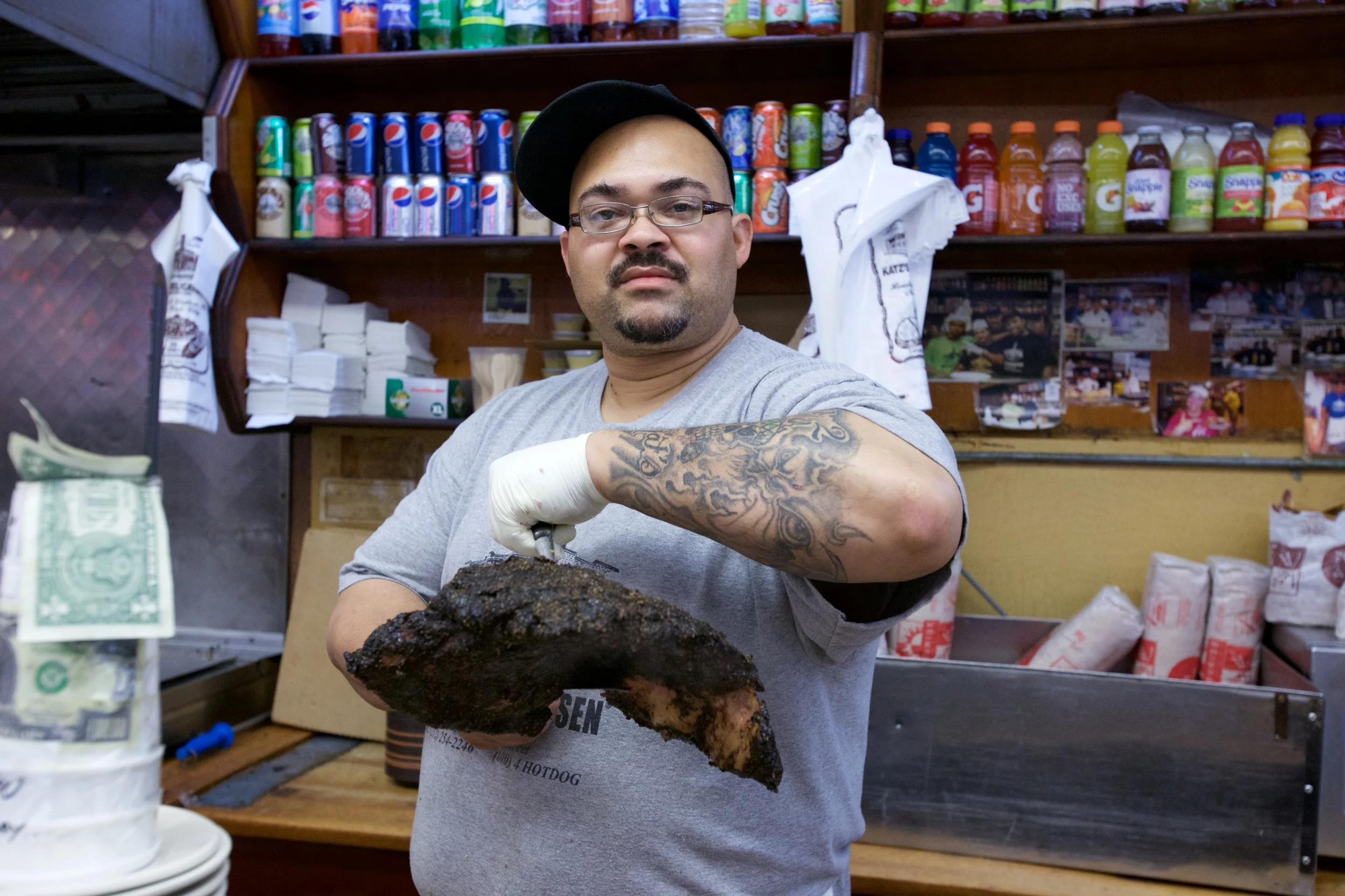 DELI MAN, ELI, HOLDING A PIECE OF PASTRAMI JUST TAKEN FROM THE STEAMER