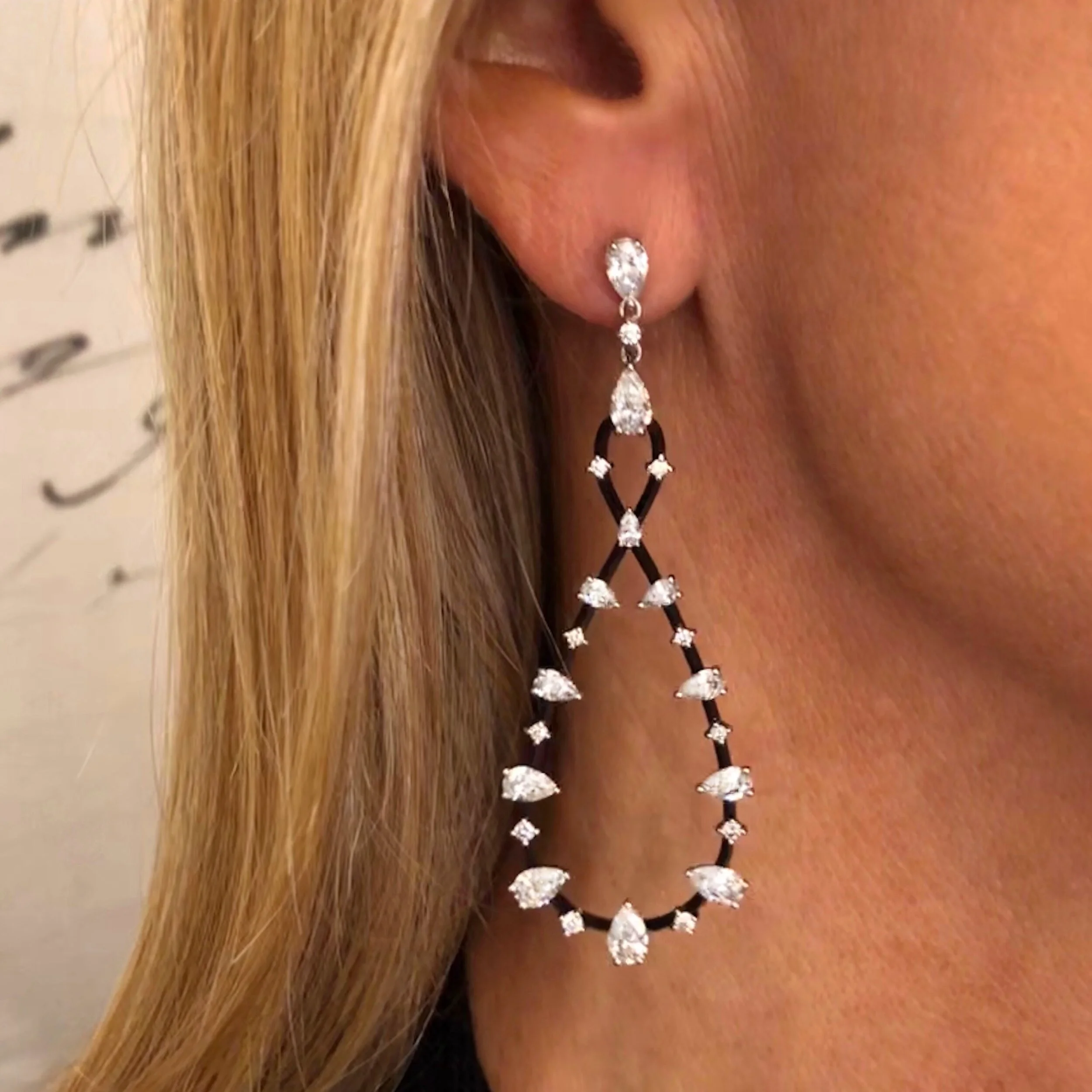 Black Gold and Diamond Eternity Earrings. These dangling earrings feature a black gold Eternity-shaped hoop, punctuated with diamonds.