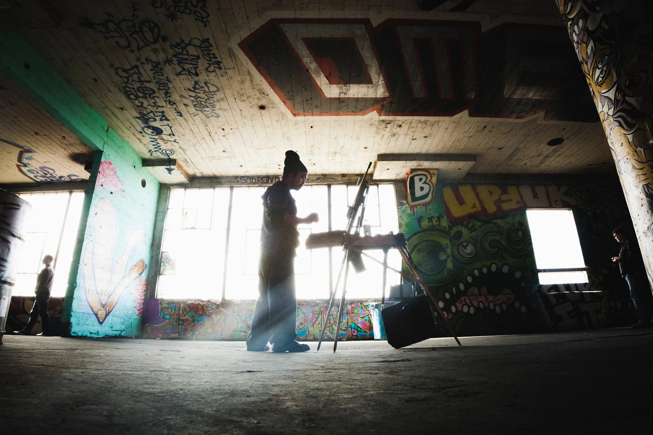 A painter sets up his easel inside the Carbon Warehouse's Art exhibition, 'Special Delivery 2012' in Berkeley, CA. A massive collaborative art exhibition put on by Endless Canvas and the Carbon Warehouse, includes art from artist all over the world. Art work from artists such as: Swampy, Pemex, GATS and Dead Eyes are just some of over fifty artist that contributed to 'painting' the entirety of the warehouse.