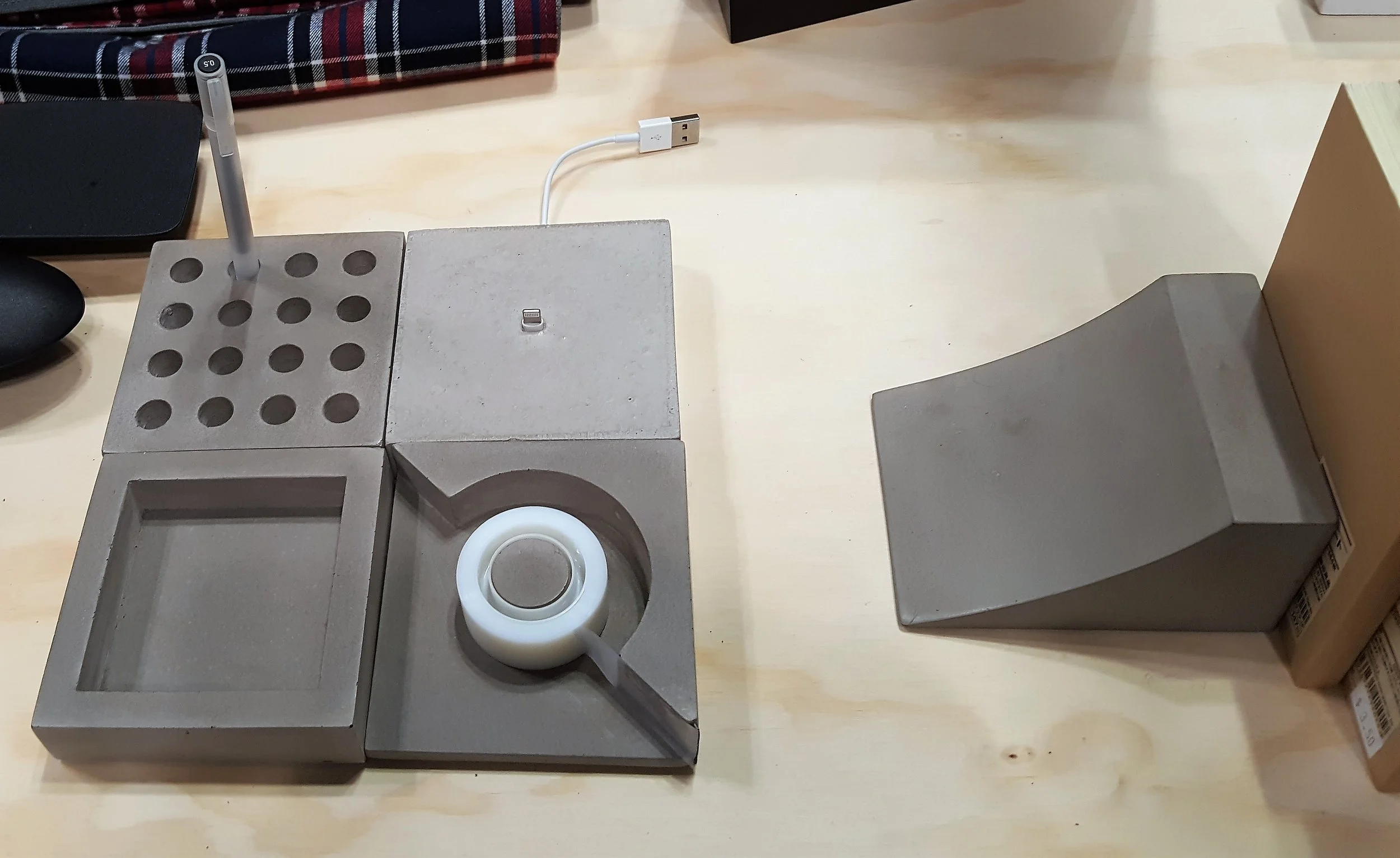 Concrete is smoothed, hand-sanded and sealed to create a modular series of 4x4x1 inch pieces. $15 per piece or $50 for set of 4 (tray, pen stand, tape dispenser, dock). Matching Book Launch is inspired by skate ramps. $29.95. Made in the USA by I Love Handles. ilovehandles.com.