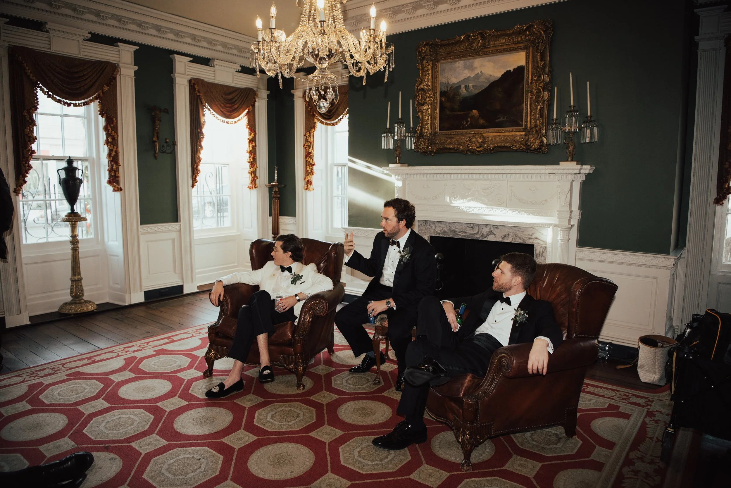 Groom and some groomsmen chilling in leather chairs before the ceremony