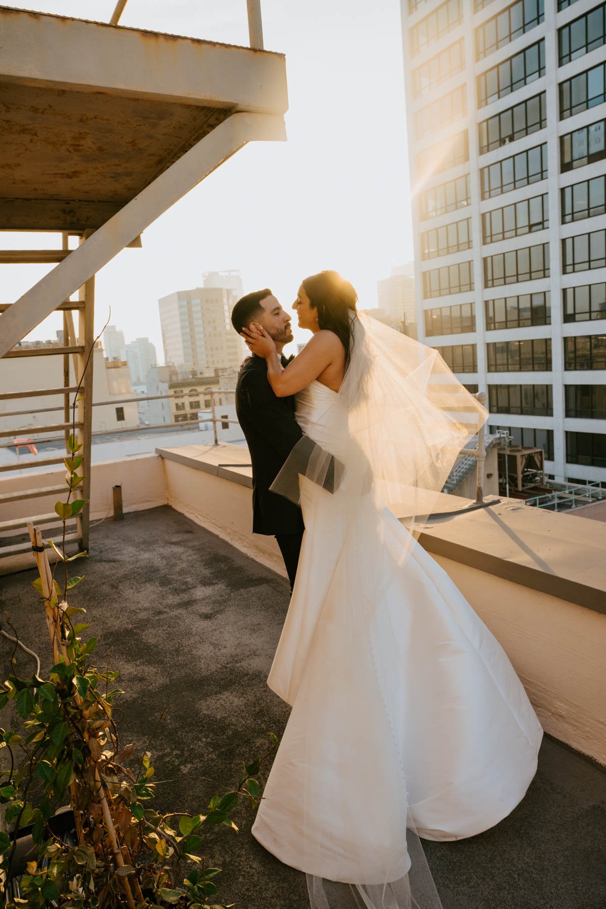 Groom has pick up the bride and is spinning ad the sun shines behind them