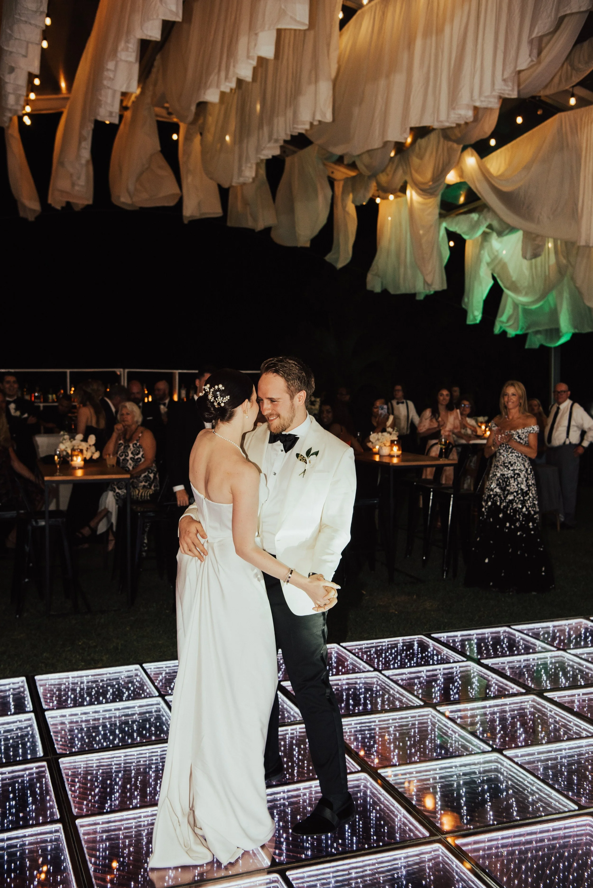 groom smiling at bride as they dance