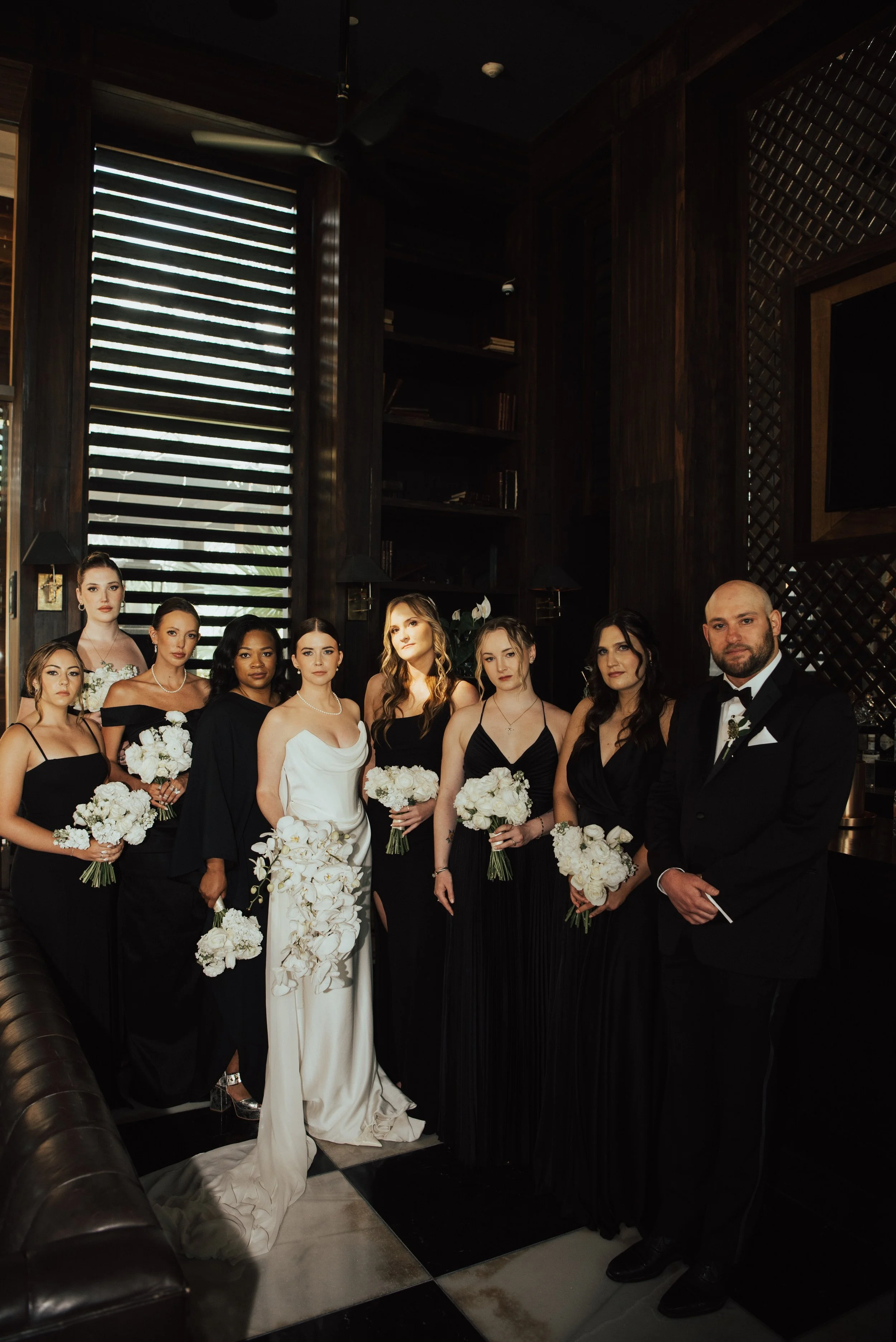 bride and her wedding party standing and staring at camera in a darkroom