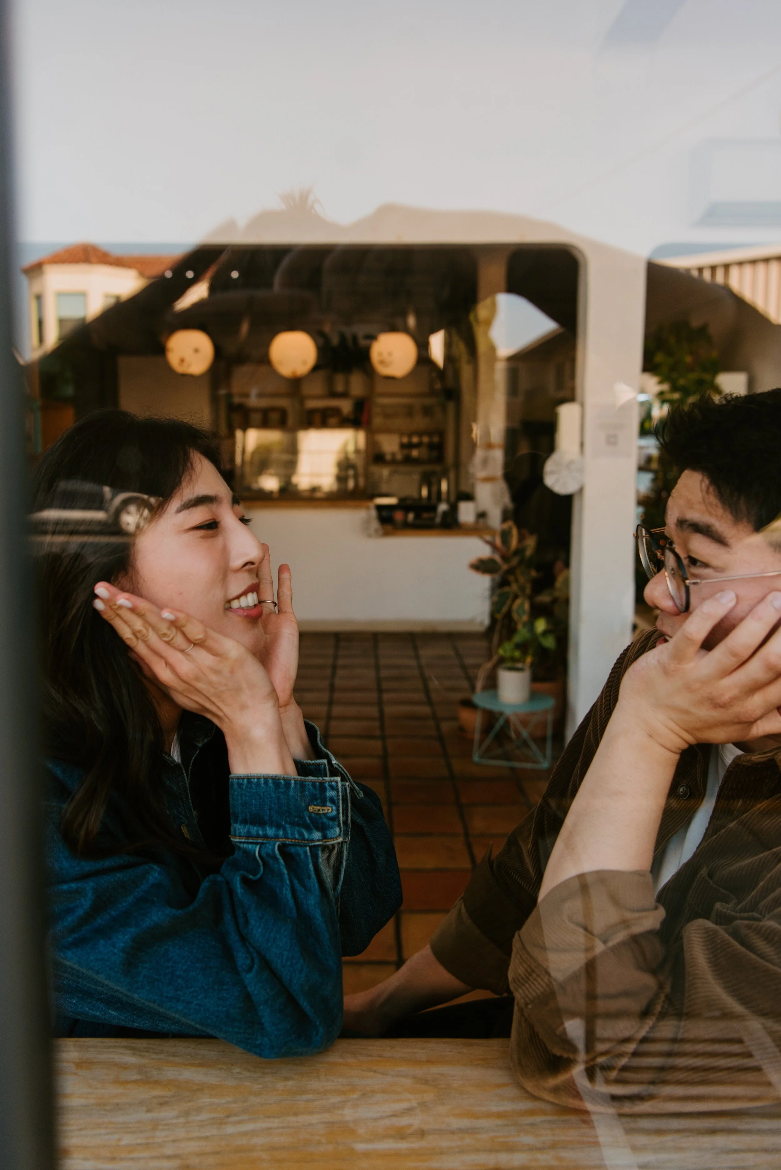 Couple making funny faces at each other in a coffee shop
