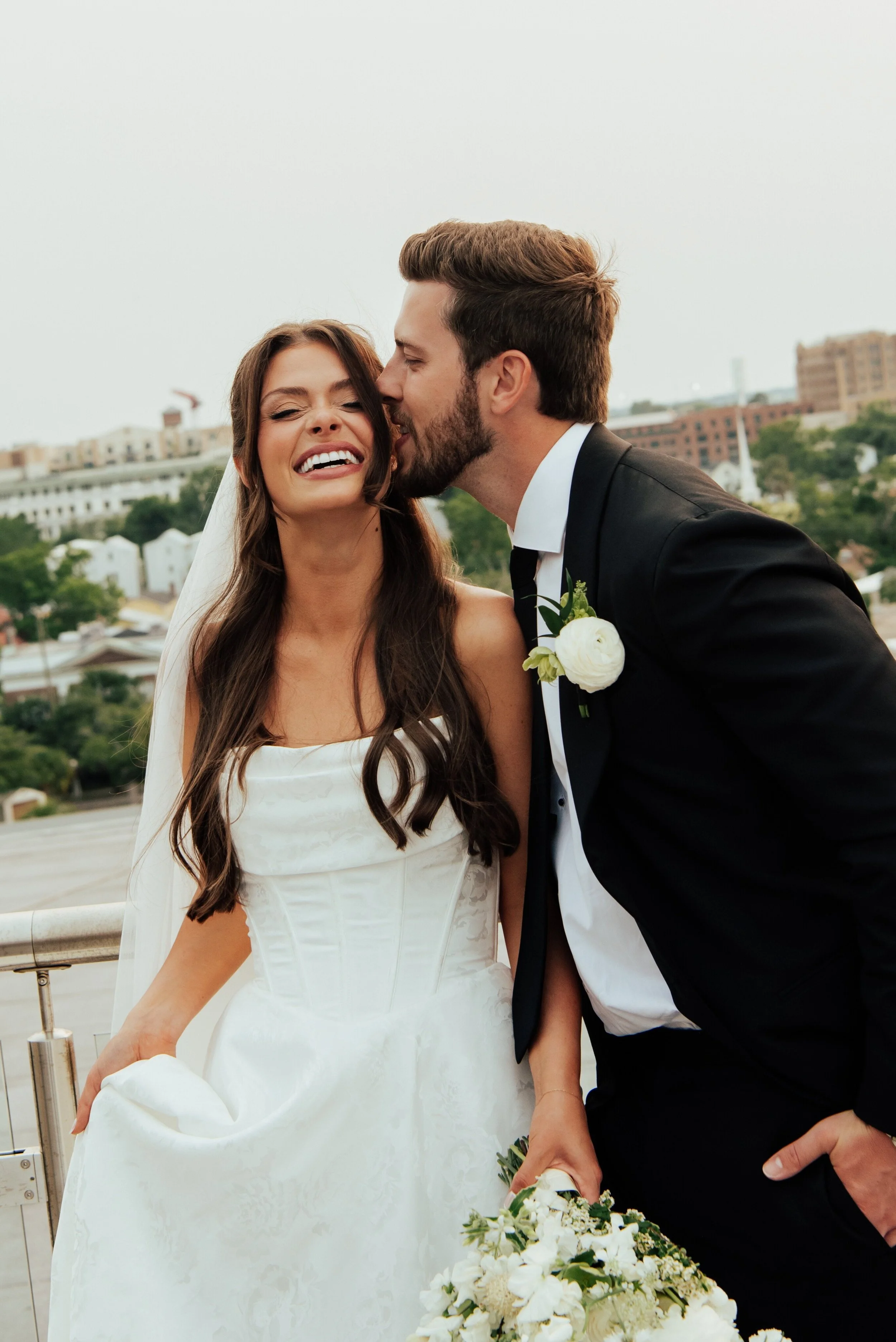 groom whispering to bride and she laughs