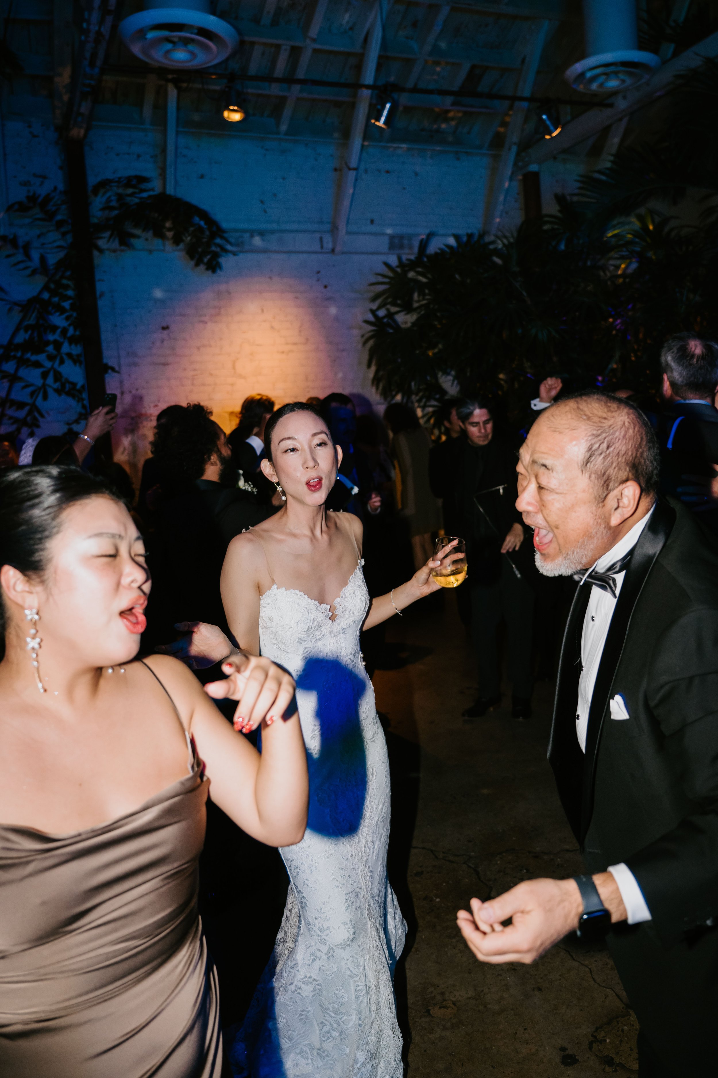 bride, Bridesmaid, and bride's grandfather singing and dancing on the dance floor