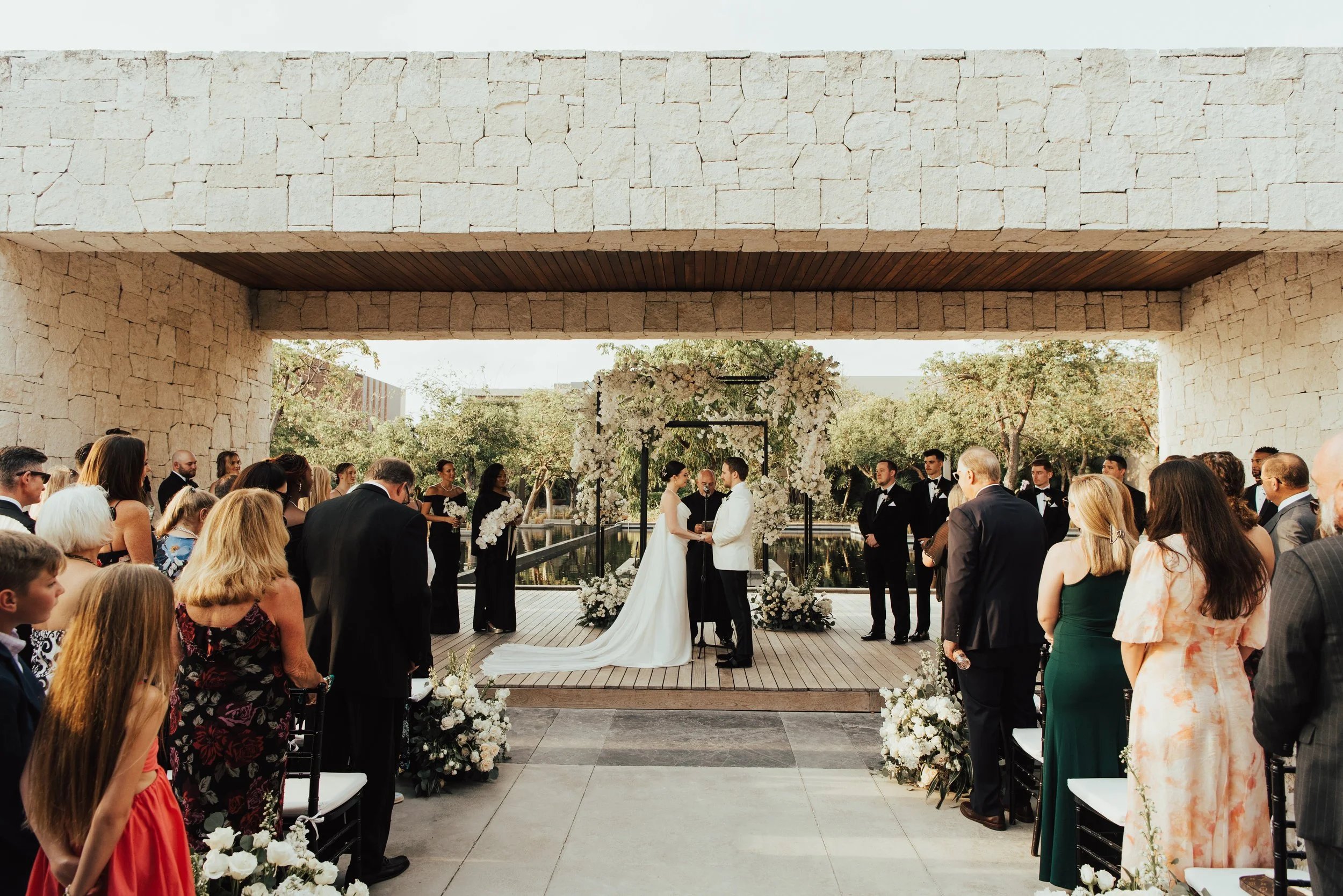 wide shot of wedding ceremony with bride and groom facing each other holding hands