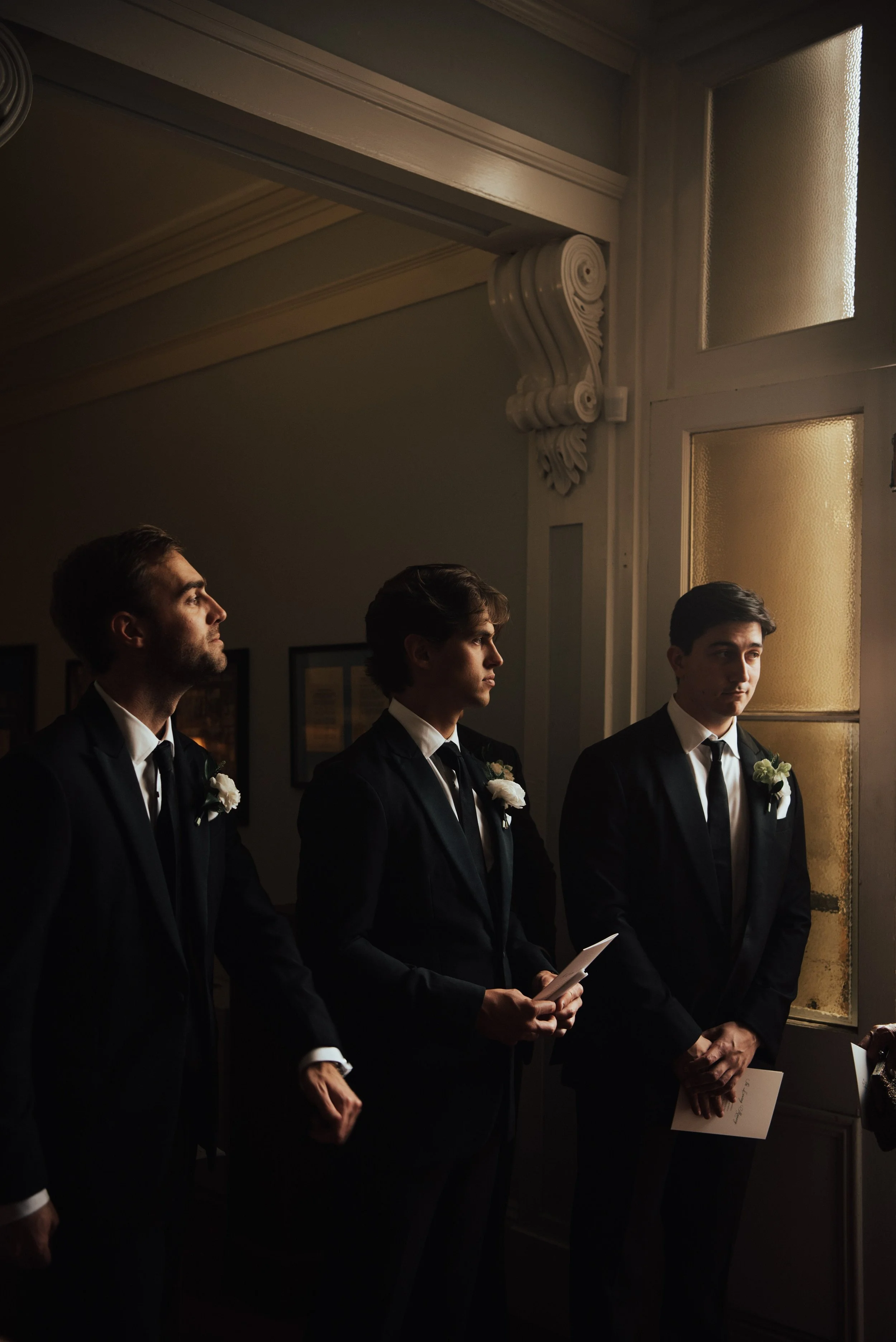 Groomsmen standing at the entrance to the church to welcome guest