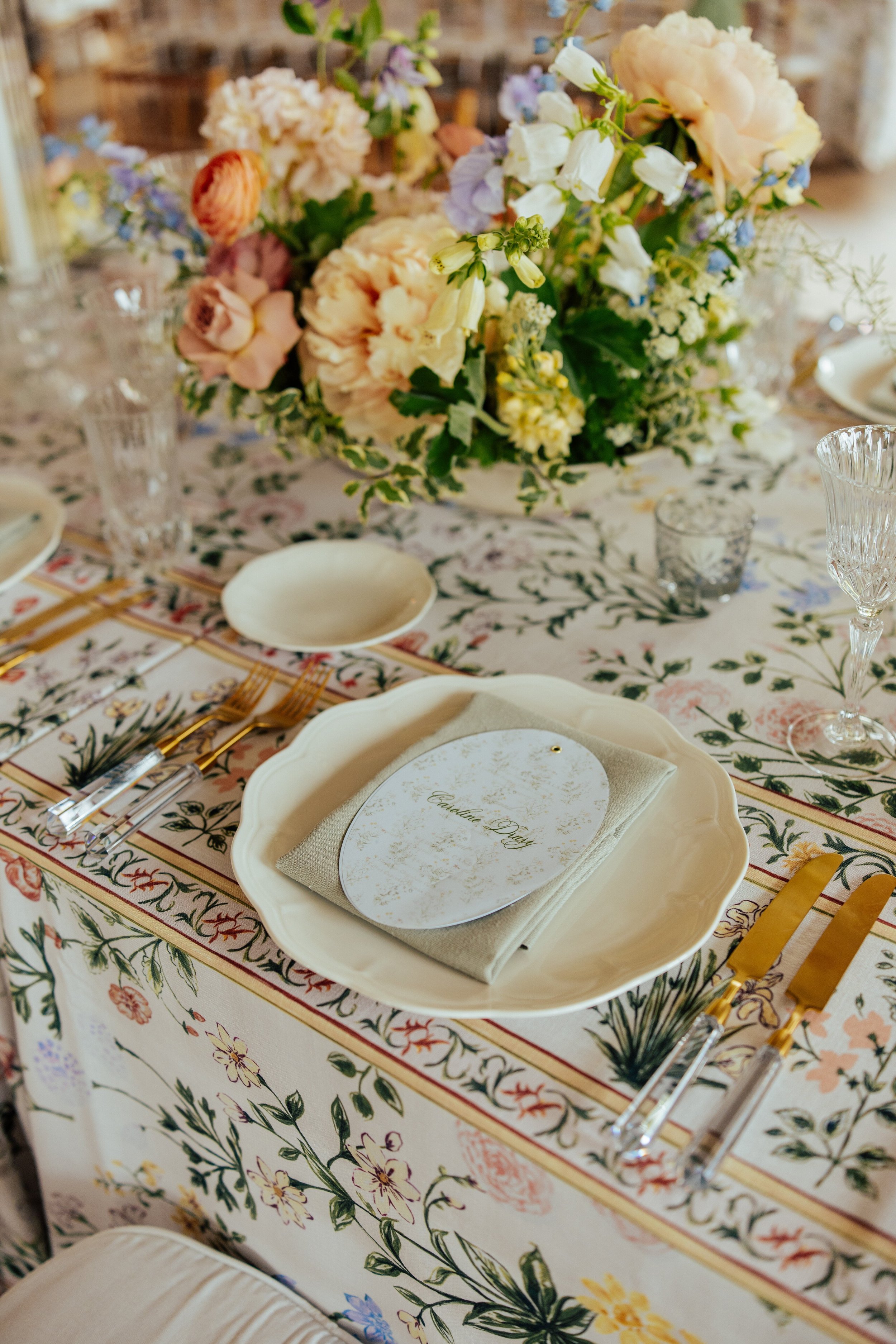 close up shot ofWedding reception table with floral table cloth and plate setting