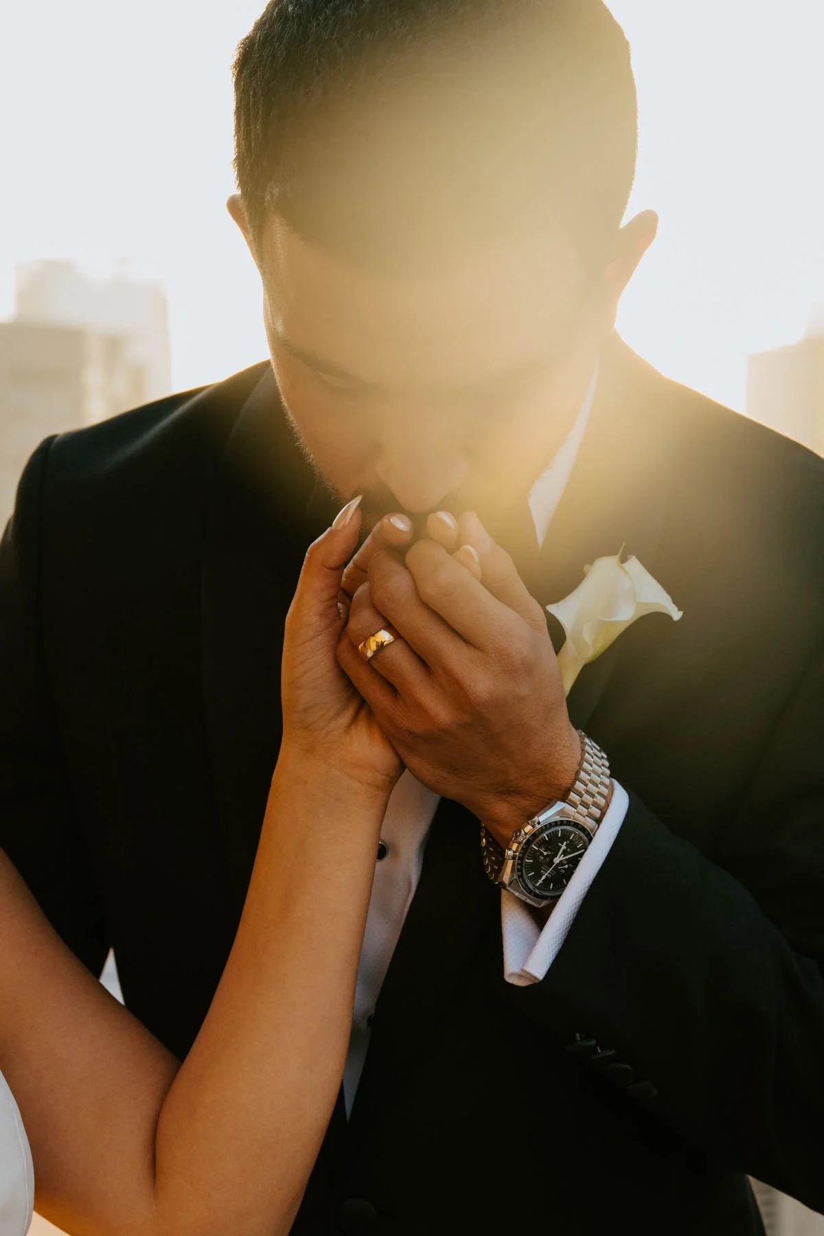 Close up shot of groom kissing the brides hand