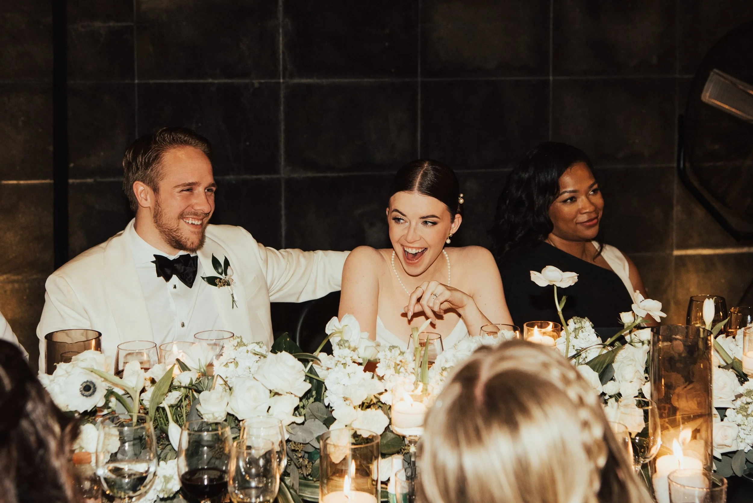 bride laughing with groom sitting next to her with his arm around her