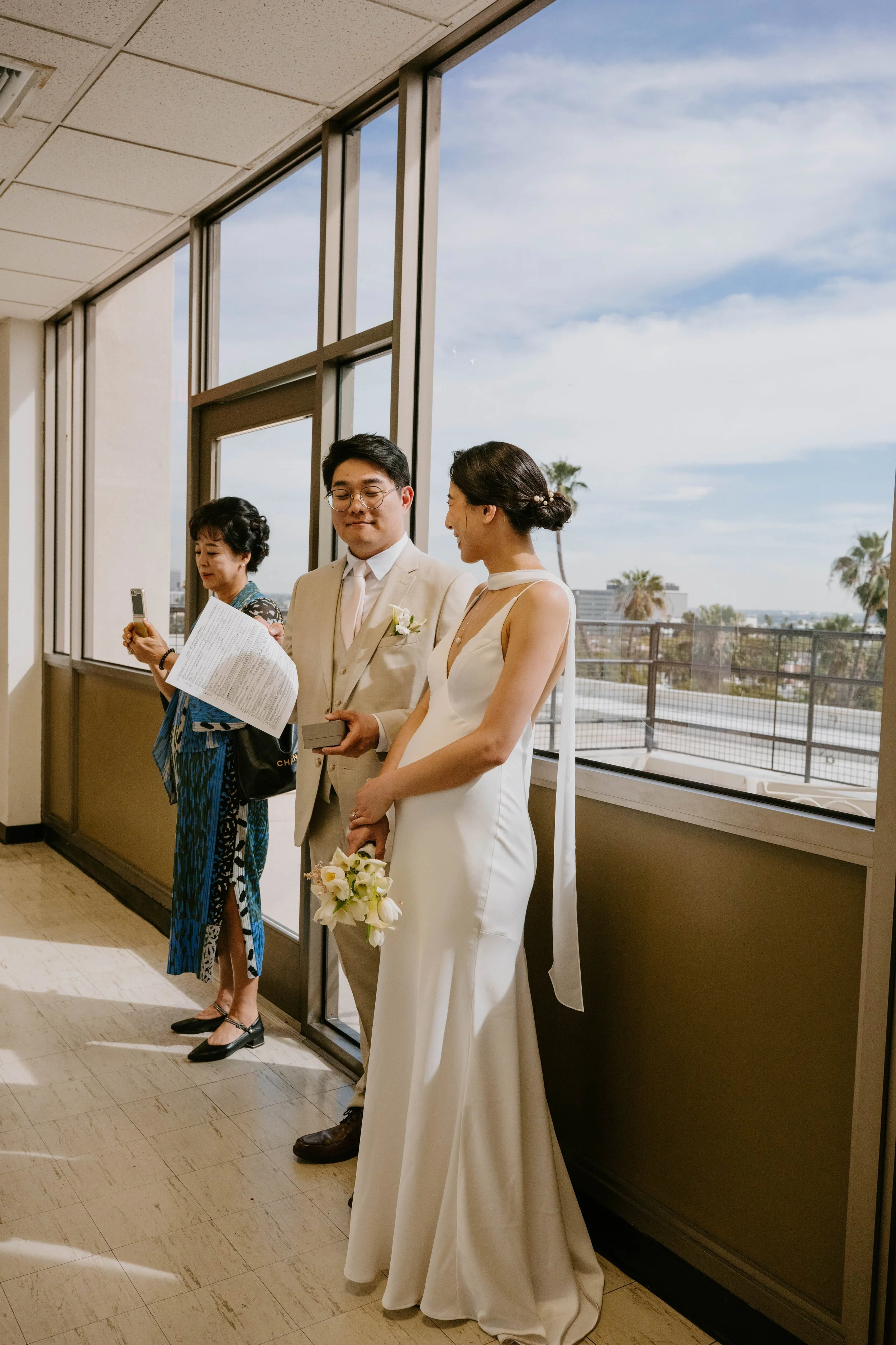 Bride and groom standing in hallway waiting for courthouse ceremony