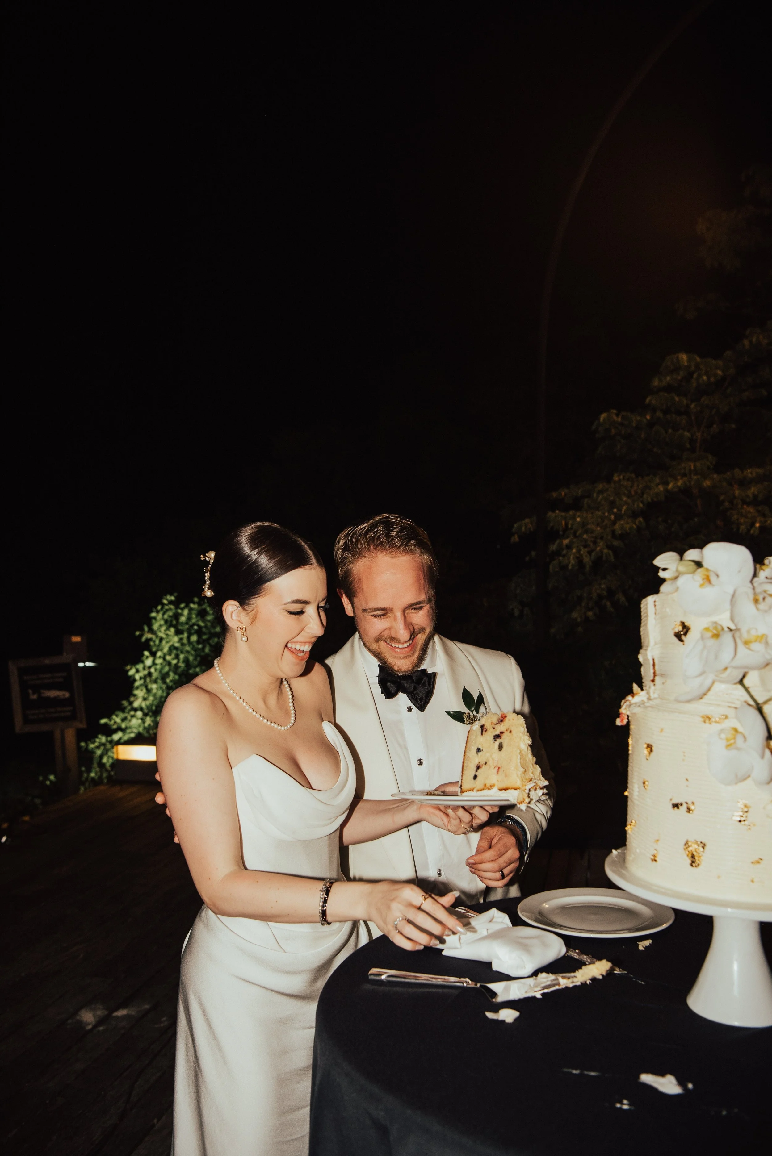 Bride and Groom smiling as the lift up a giant piece of cake.