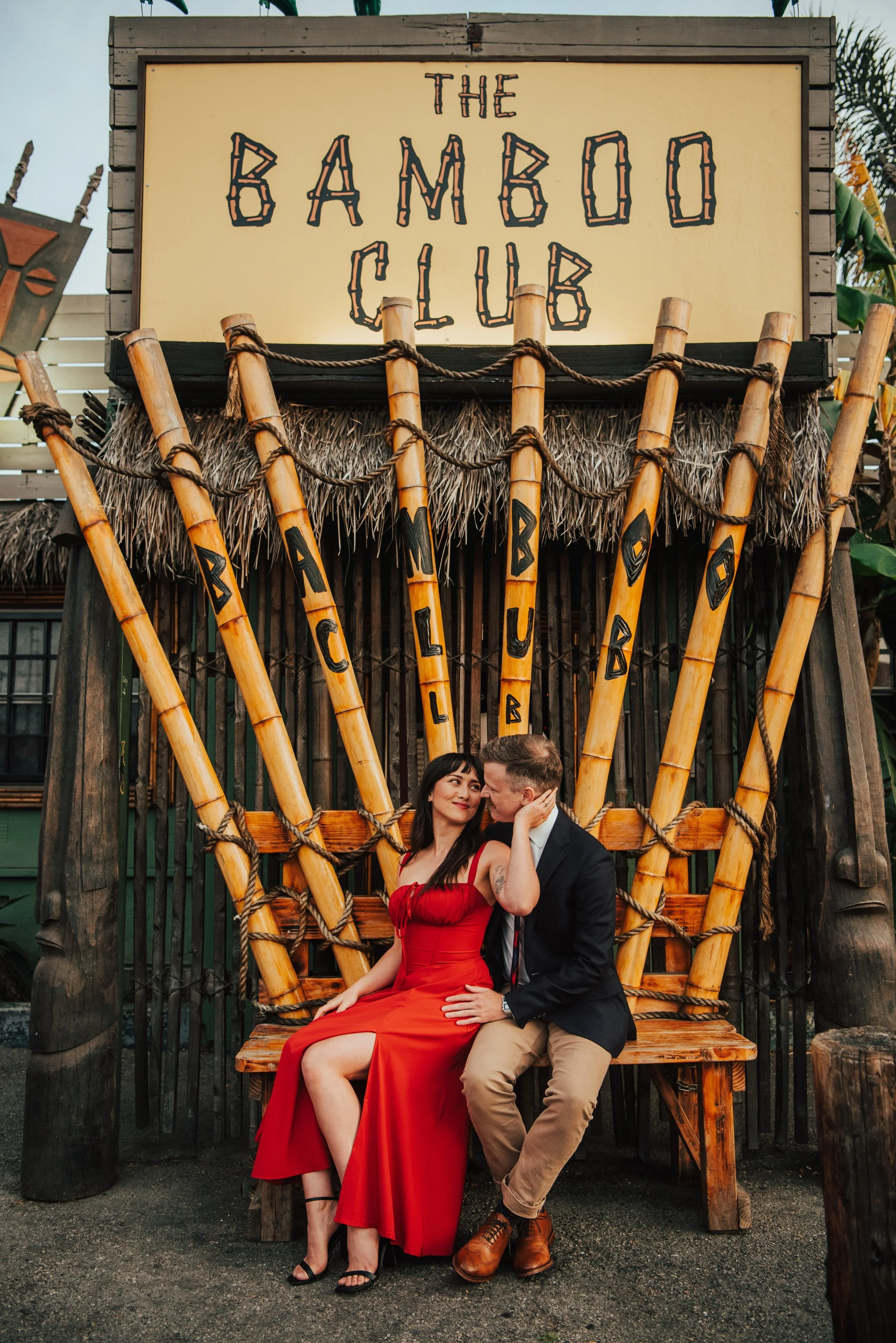Couple sitting and looking at each other in front of the Bamboo Club in Long Beach California