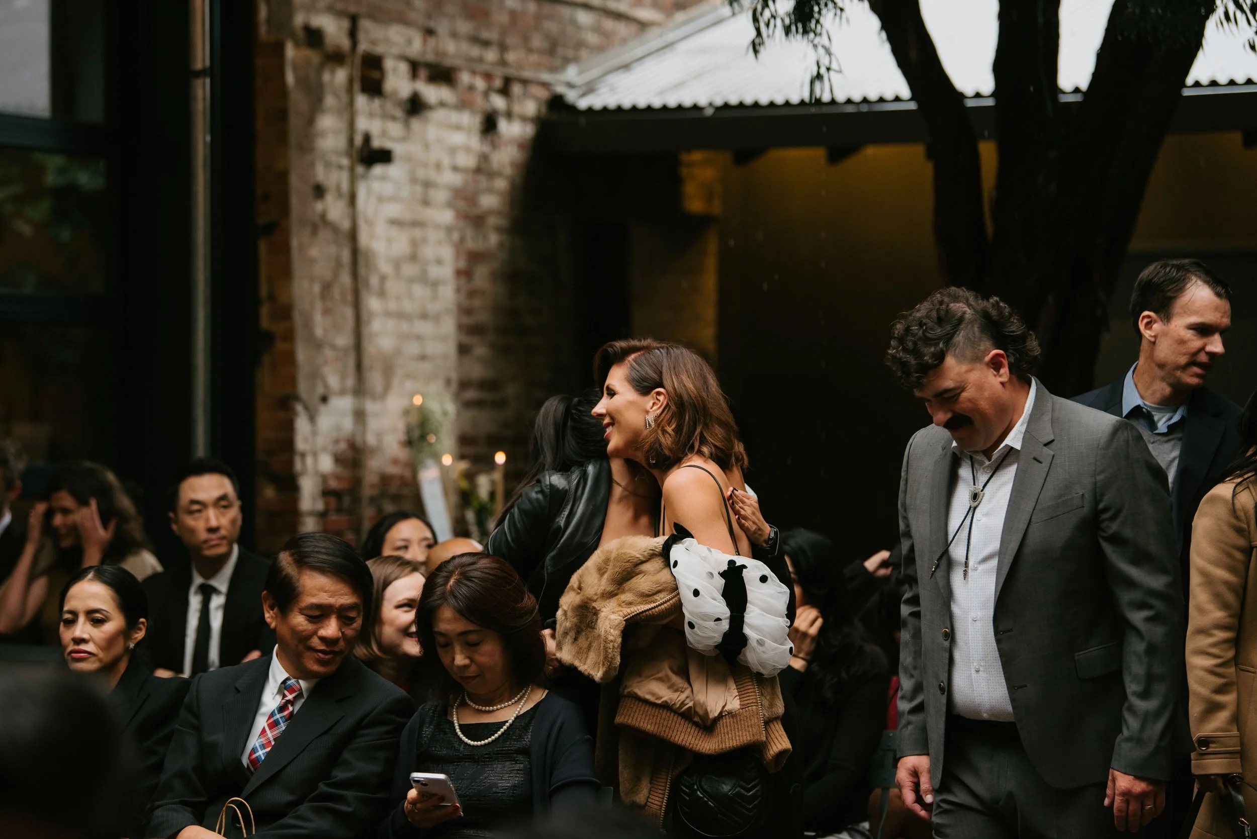 wedding guest hugging before ceremony begins