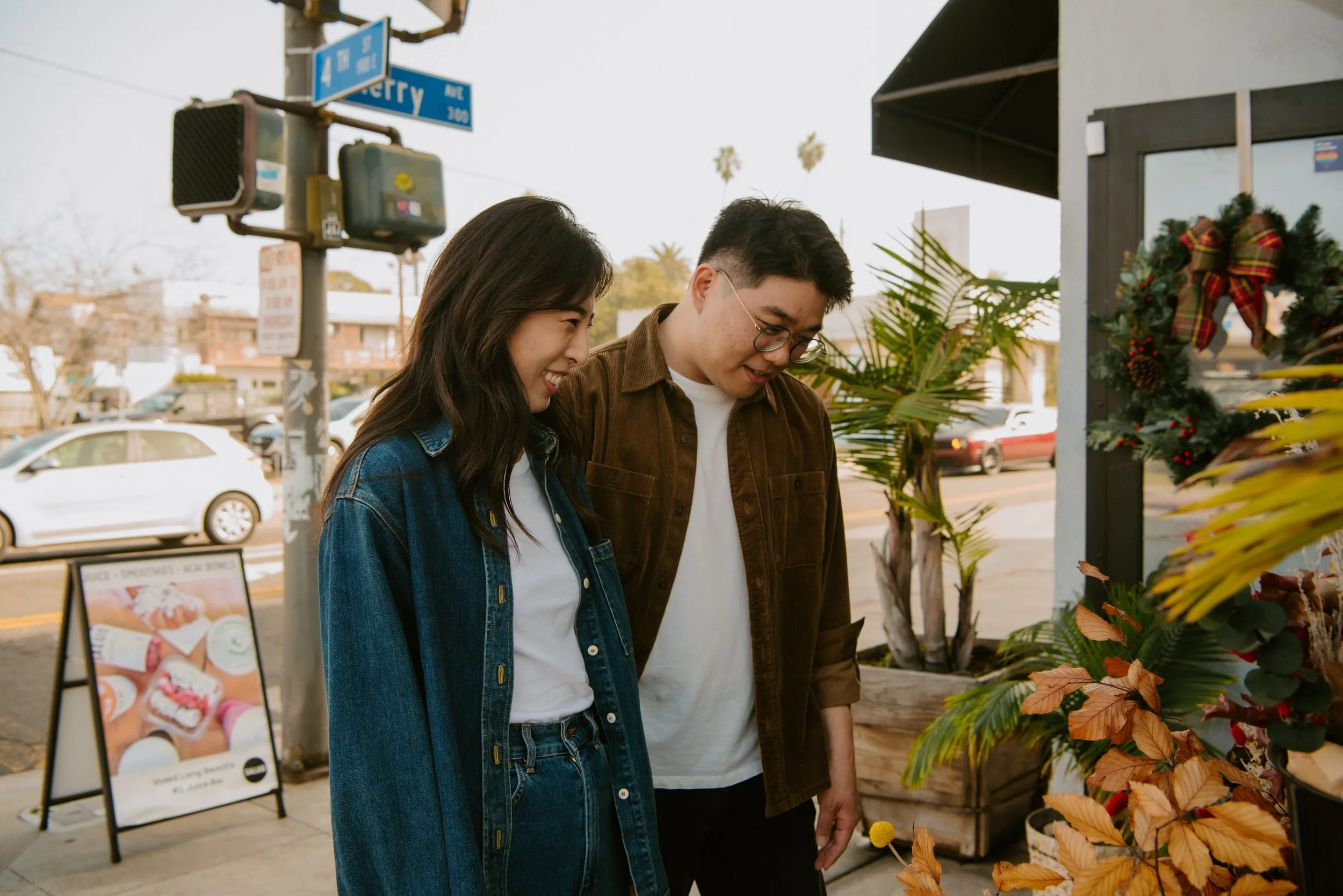 Couple standing in from of a store picking out flowers.