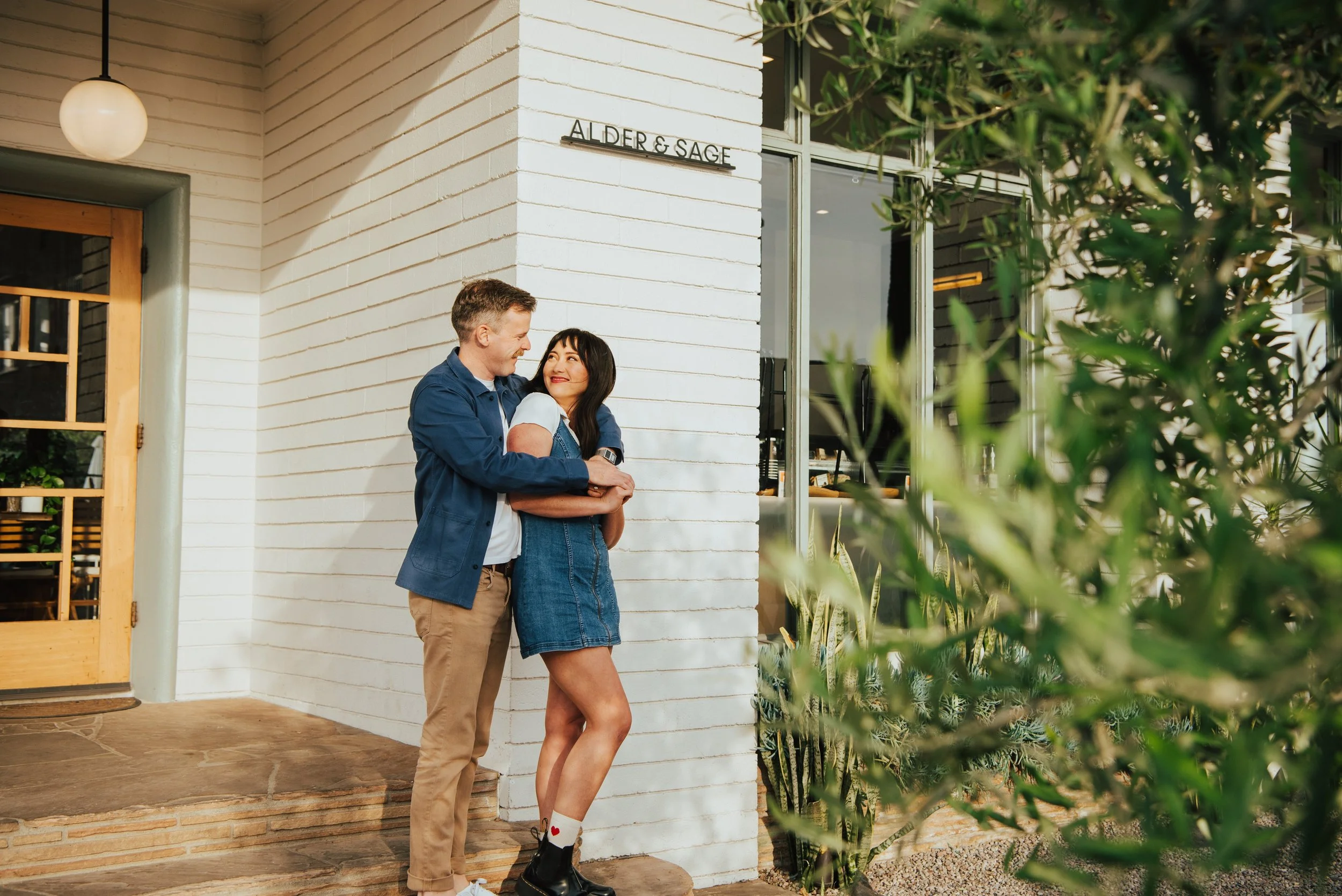 shot of guy hugging girl from behind as they smile at each other.