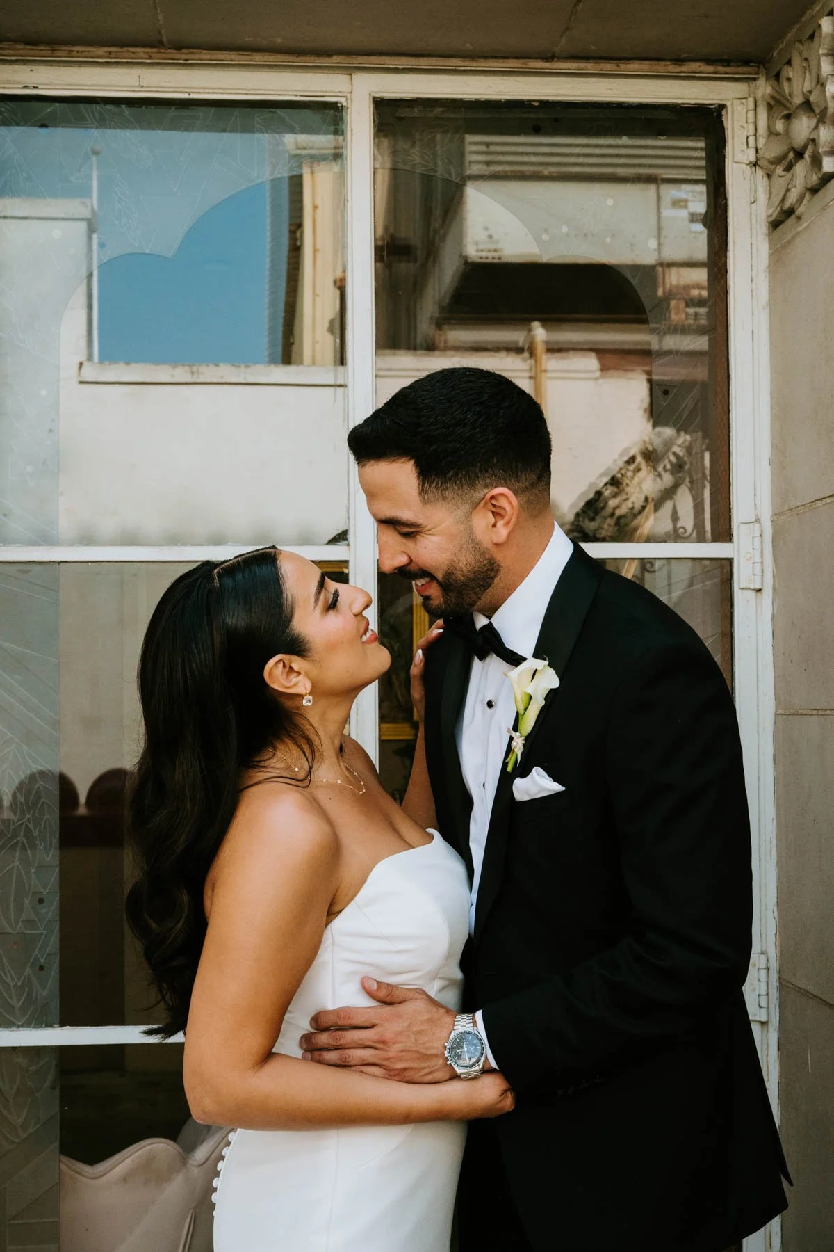 Bride and groom embracing and smiling as they look into each other eyes
