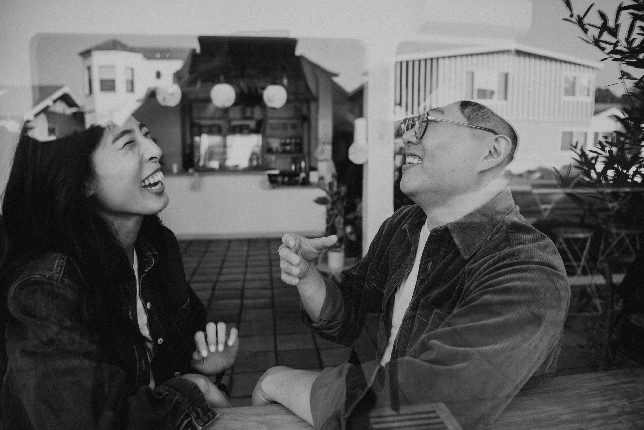 Black and white photo of couple laughing in a coffee shop